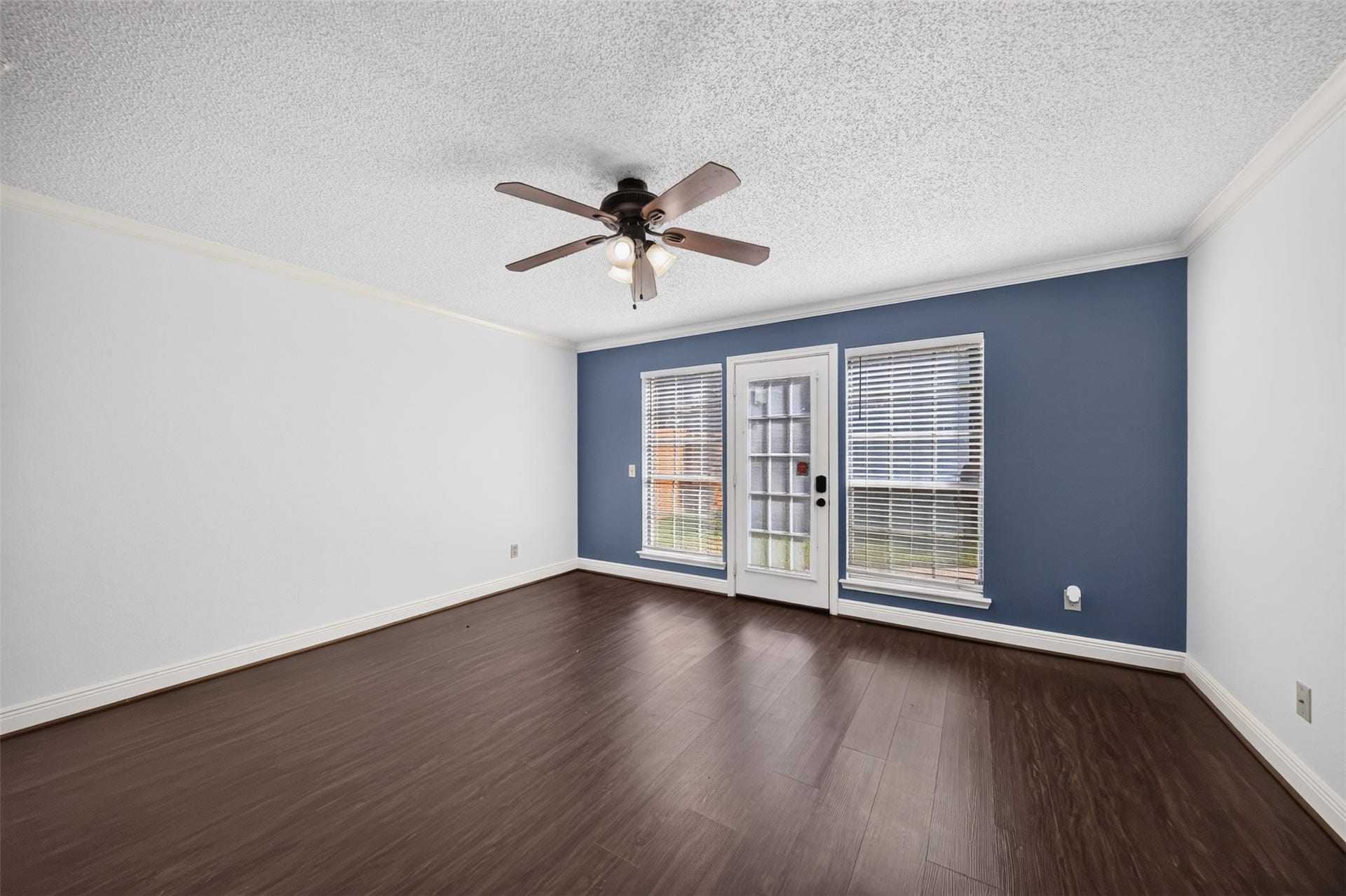 10215 Minturn Lane, Houston, TX 77064 Spacious bedroom with wood look flooring, ceiling fan, and large windows.