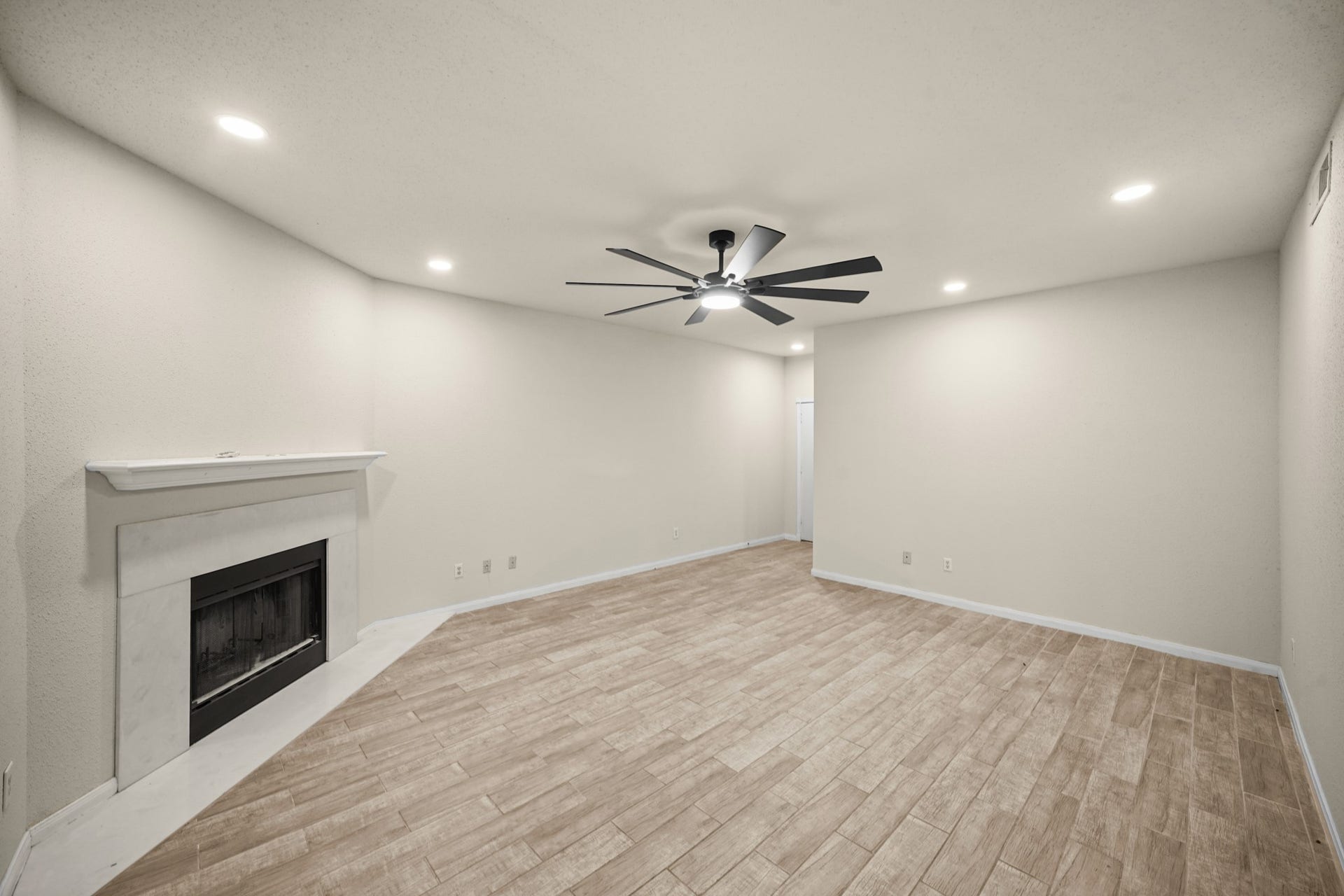 View of living area from back of condo showcasing the cozy fireplace.