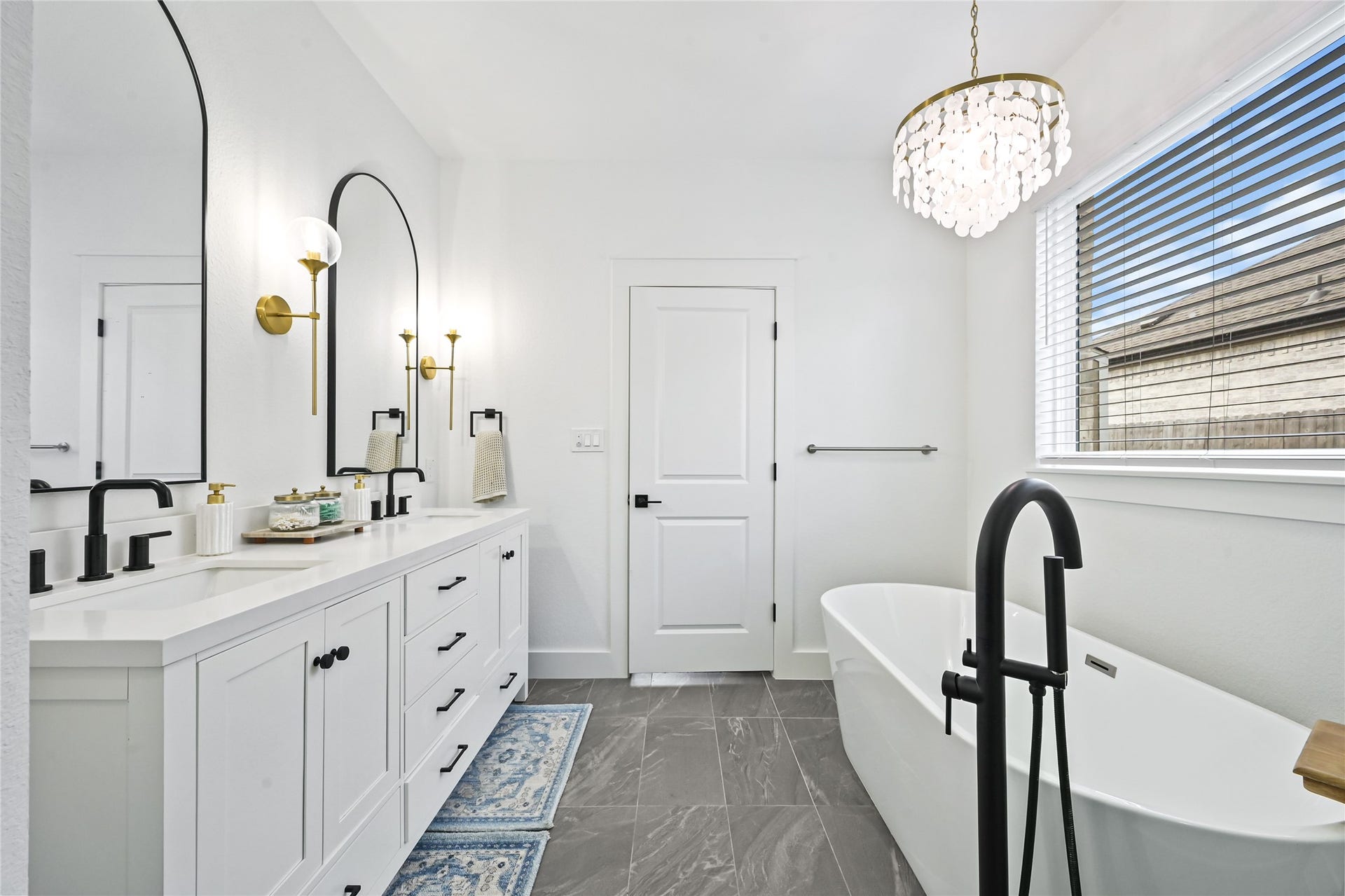 4121 Hazy Rock Lane, League City, TX 77573 The spacious layout features a gorgeous double-sink vanity with crisp white cabinetry, sleek black fixtures, and elegant arched mirrors