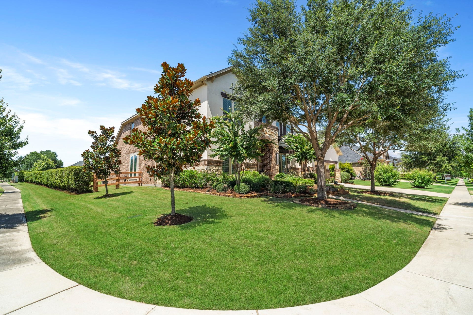 29826 Deer Crest Lane, Fulshear, TX 77406 Beautifully landscaped corner lot with mature trees, manicured lawn & lush greenery creating an impressive setting around the home.