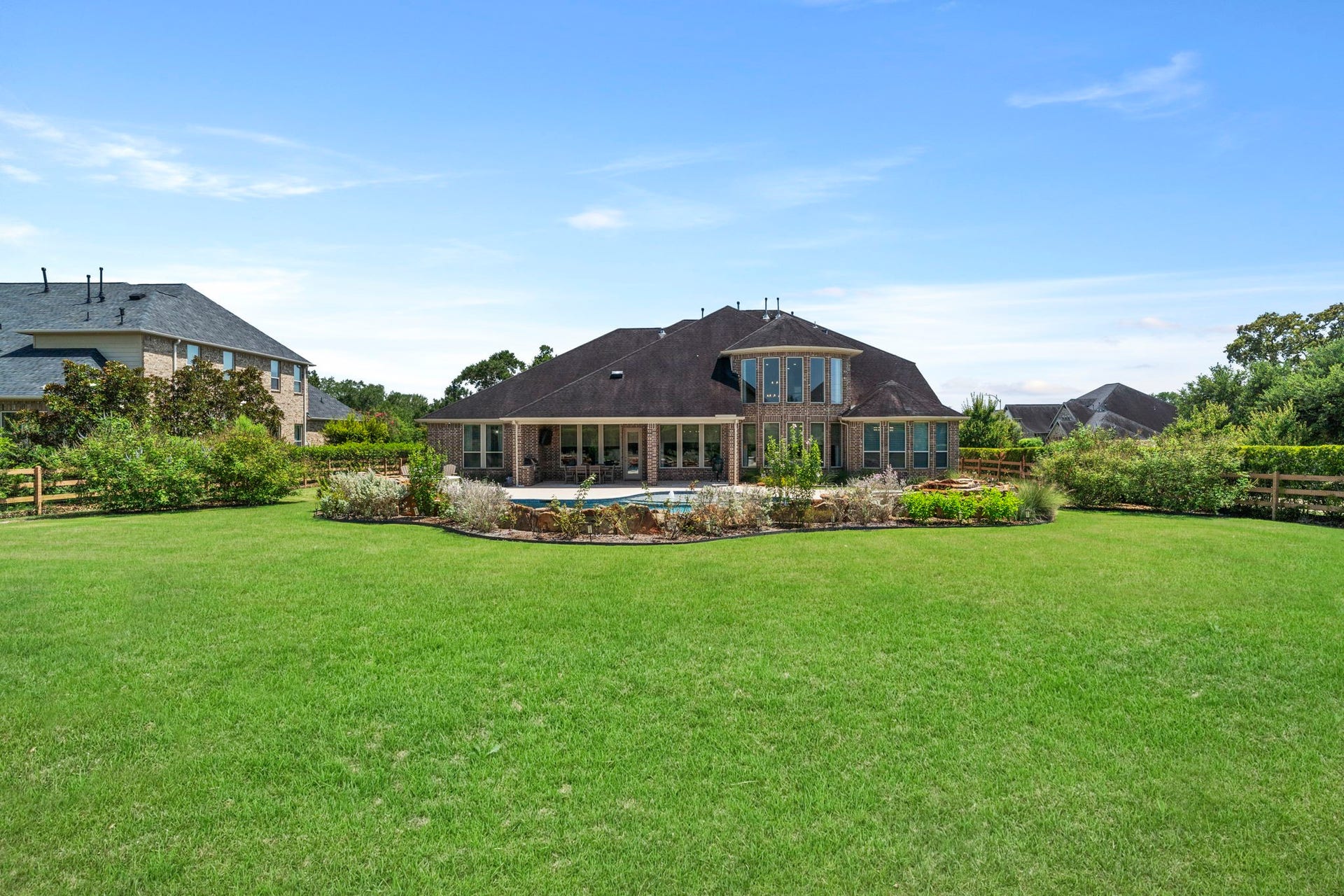 29826 Deer Crest Lane, Fulshear, TX 77406 An expansive backyard offers abundant green space beyond the custom pool, surrounded by mature landscaping & plenty of room to play, relax or entertain.