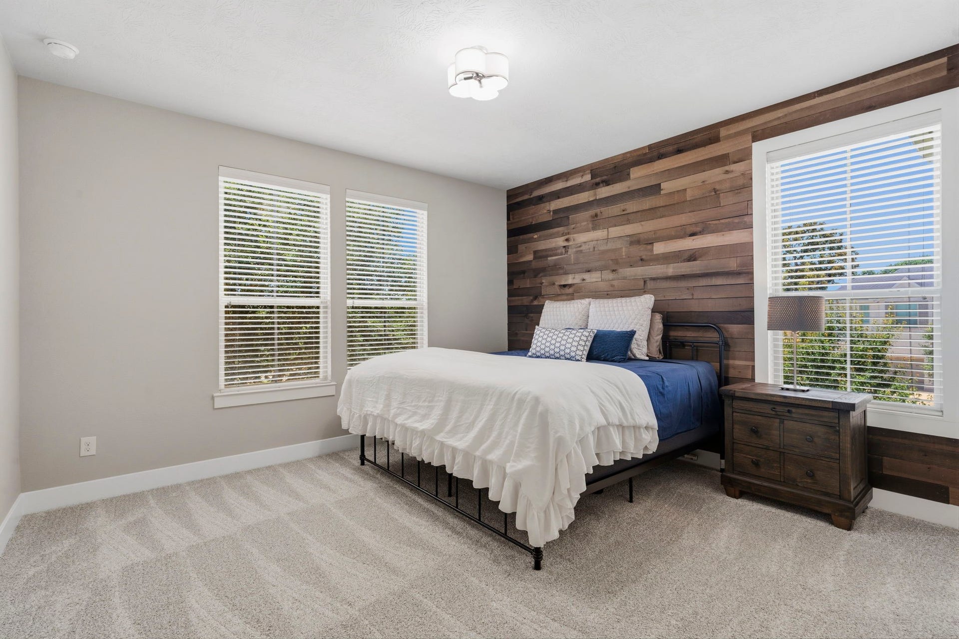 29826 Deer Crest Lane, Fulshear, TX 77406 A spacious secondary bedroom features a warm wood accent wall, abundant natural light & new carpet.