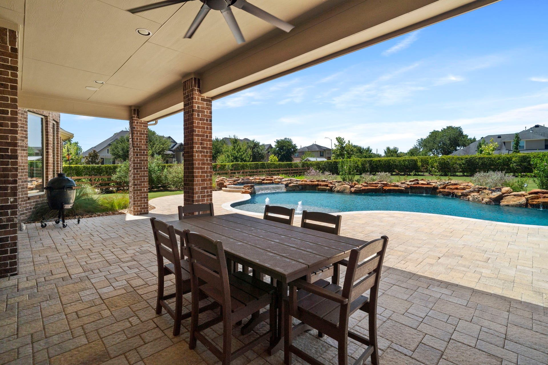29826 Deer Crest Lane, Fulshear, TX 77406 Expansive covered outdoor living overlooks the custom pool & lush backyard, creating the perfect setting for dining, relaxing & entertaining.