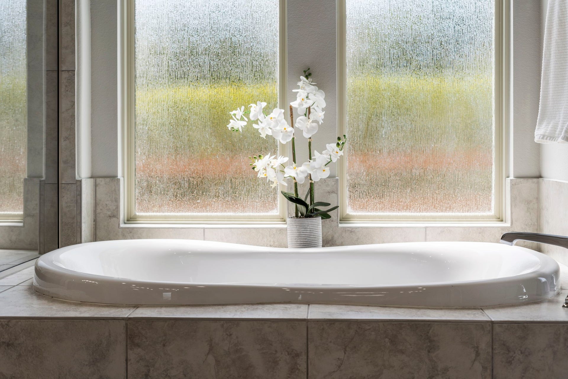 29826 Deer Crest Lane, Fulshear, TX 77406 A jetted soaking tub beneath privacy-glass windows creates a relaxing focal point within the primary bath.