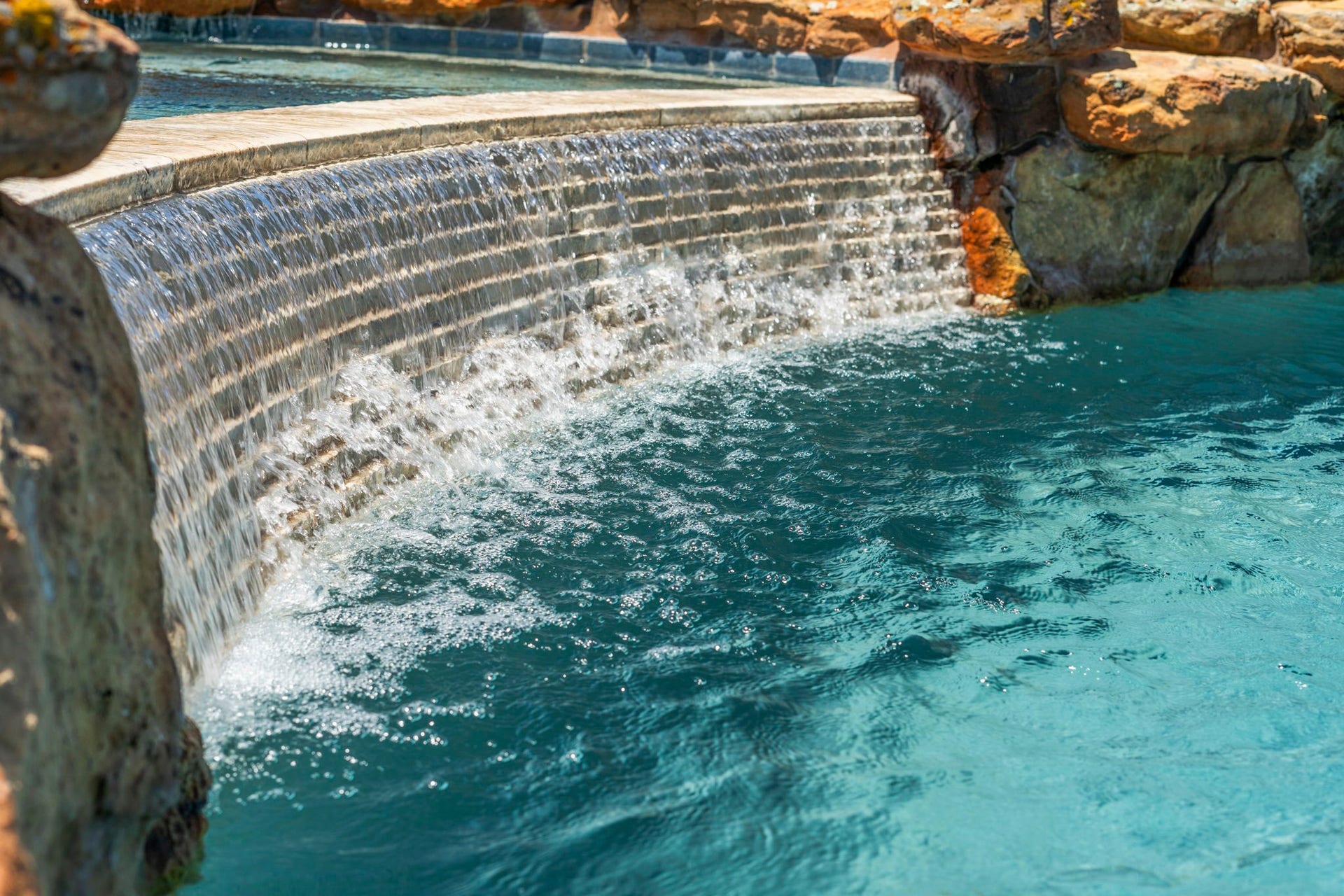 29826 Deer Crest Lane, Fulshear, TX 77406 A dramatic cascading waterfall creates a striking focal point, adding movement & sound to the custom pool design.