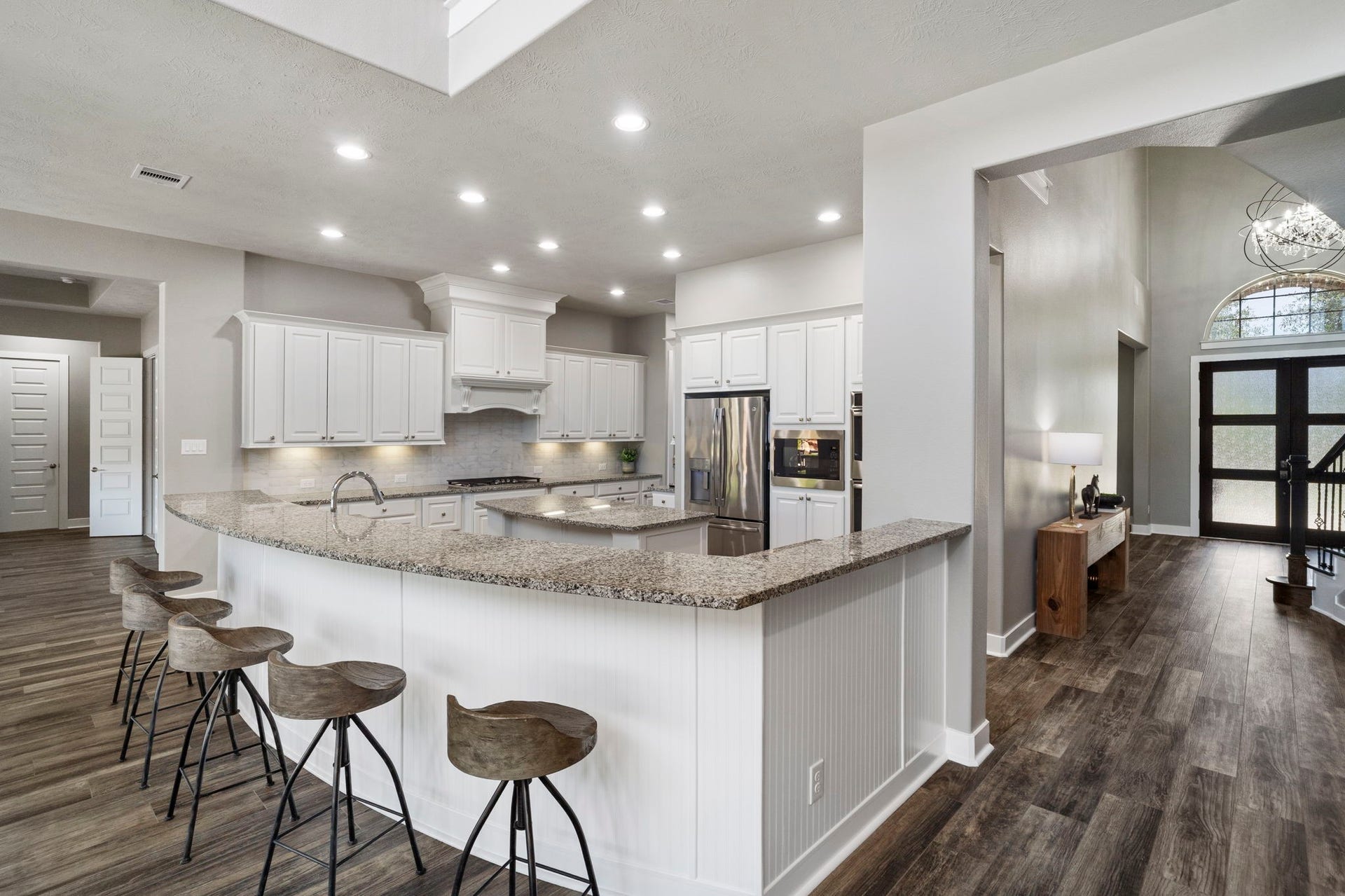 29826 Deer Crest Lane, Fulshear, TX 77406 This view highlights the kitchens expansive wraparound breakfast bar, offering generous seating & a natural connection to the main living areas.