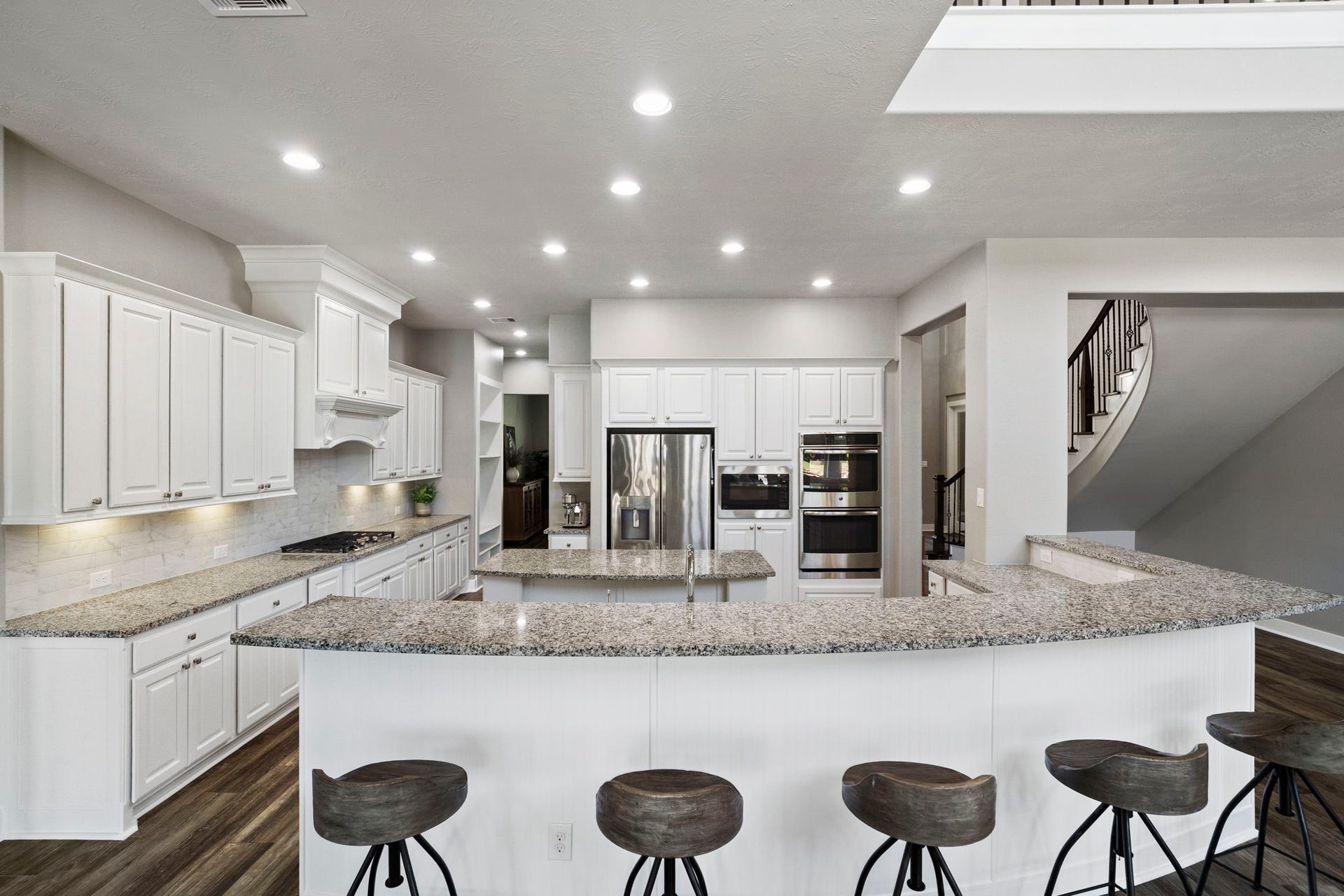 29826 Deer Crest Lane, Fulshear, TX 77406 The spacious kitchen offers abundant cabinetry & counter space, stainless steel appliances and an expansive breakfast bar with seating for five, all designed for easy everyday living & entertaining.