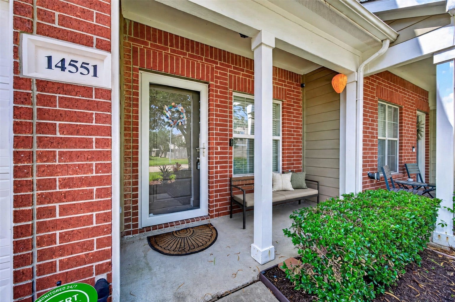 Meet your neighbors while sipping coffee on the inviting covered front porch of this classic brick home. A glass storm door installed in 2024, a programmable porch-light timer, and neatly manicured landscaping create welcoming curb appeal. **Virtually Staged.**