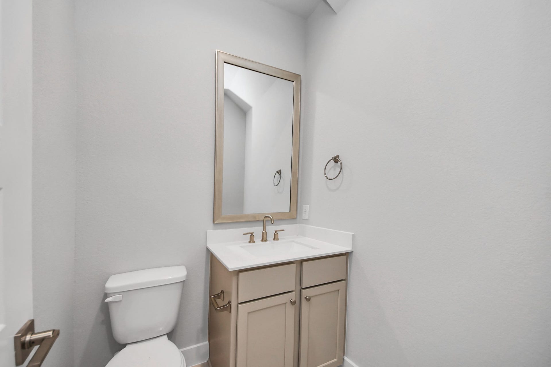 3205 Skerne Spring Drive, Spring, TX 77373 Sophisticated half bathroom adorned with contemporary finishes. The elegant 5-panel door welcomes you to a space where style meets functionality. Notice the sleek hardware accents that add a touch of modern charm. The vanity boasts light-colored countertops, beautifully complemented by a tasteful vanity light, creating a well-lit and inviting atmosphere. Sample photo of completed home with similar floor plan. Actual colors and selections may vary.