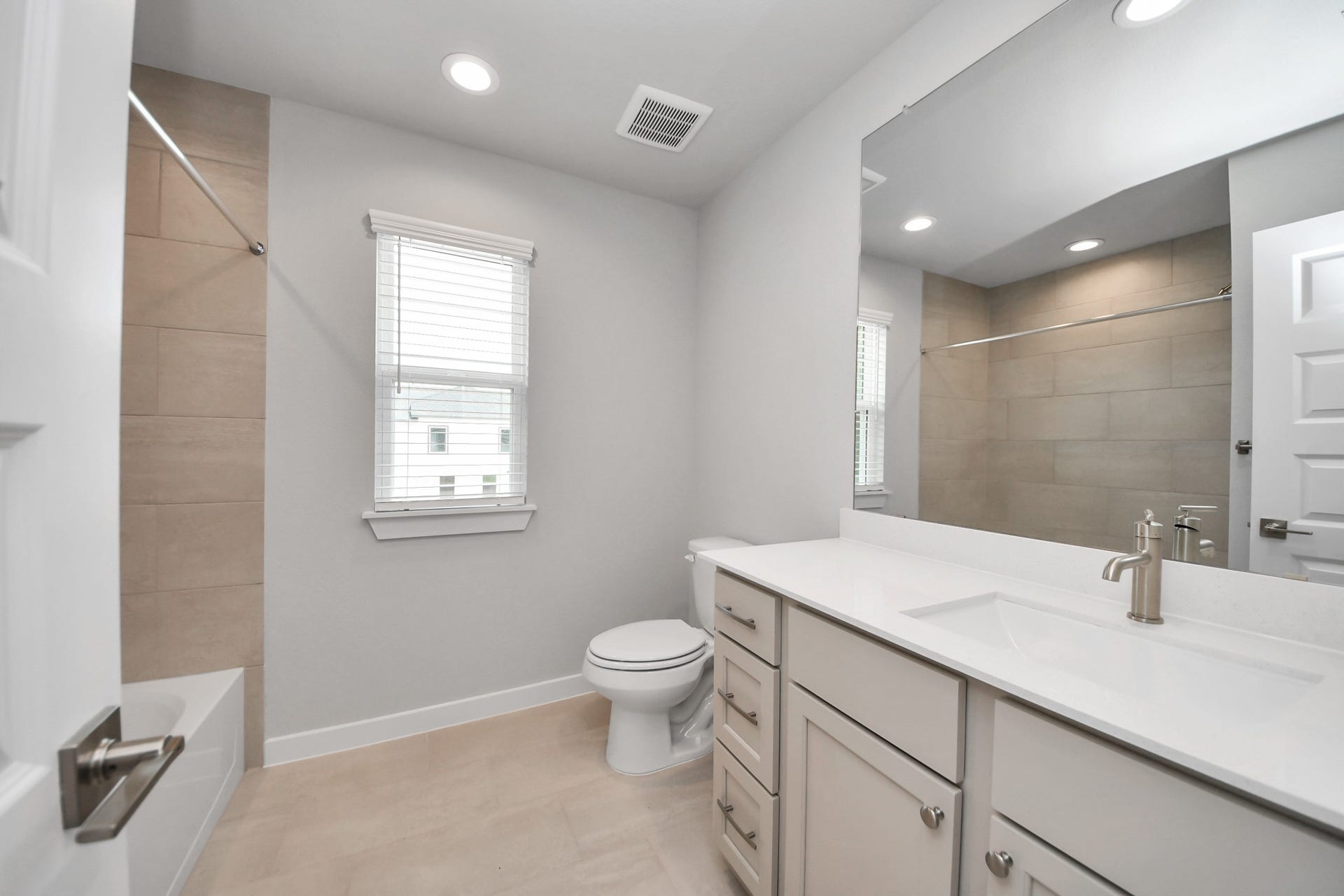 3205 Skerne Spring Drive, Spring, TX 77373 Secondary bath features tile flooring, walk-in shower with tile surround, light stained wood cabinets, beautiful light countertop. Sample photo of completed home with similar floor plan. Actual colors and selections may vary.