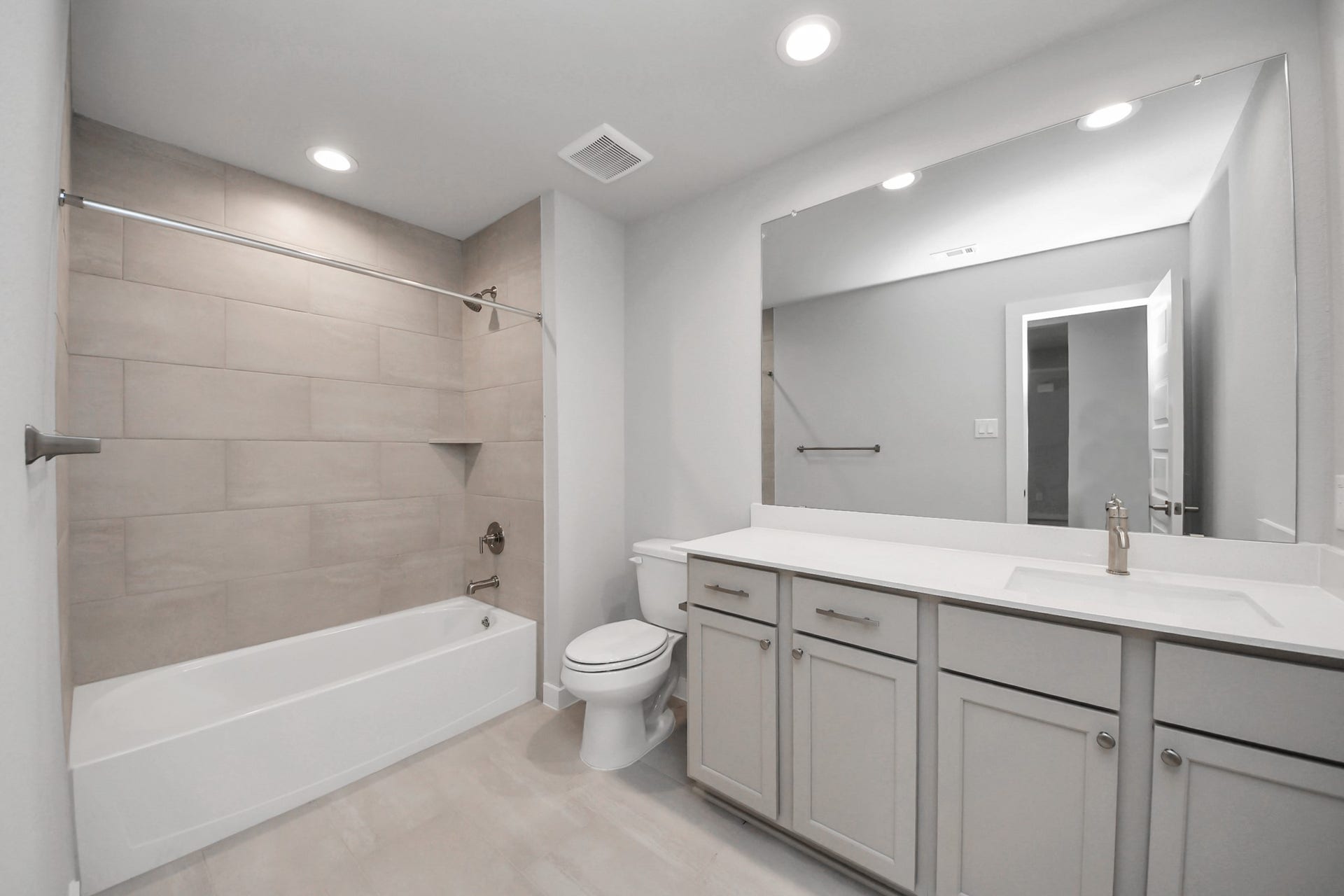 3205 Skerne Spring Drive, Spring, TX 77373 Secondary bath features tile flooring, bath/shower combo with tile surround, light stained wood cabinets, beautiful light countertop. Sample photo of completed home with similar floor plan. Actual colors and selections may vary.
