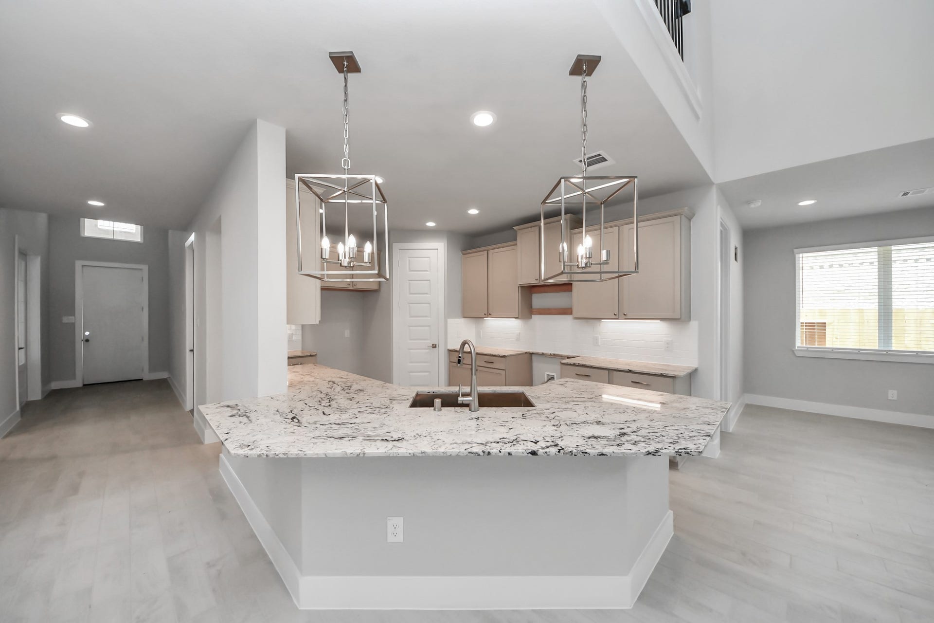 3205 Skerne Spring Drive, Spring, TX 77373 This kitchen is truly a chef's dream! This haven Boasts high ceilings, recessed & pendant lighting, stained wood cabinets, granite countertops, stainless steel appliances, a modern tile backsplash. All of this overlooks your expansive family room, creating a perfect space for culinary delights and family gatherings. Sample photo of completed home with similar floor plan. Actual colors and selections may vary.