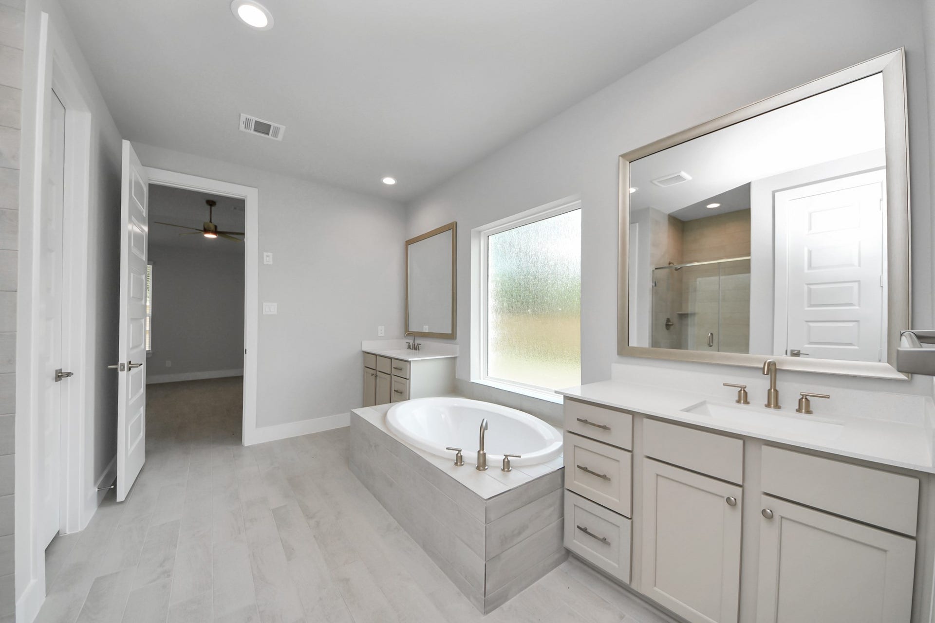 3205 Skerne Spring Drive, Spring, TX 77373 Elevate your daily routine at the elegant vanity, now equipped with double sinks, light countertops, modern hardware, and beautiful recessed lights. Sample photo of completed home with similar floor plan. Actual colors and selections may vary.