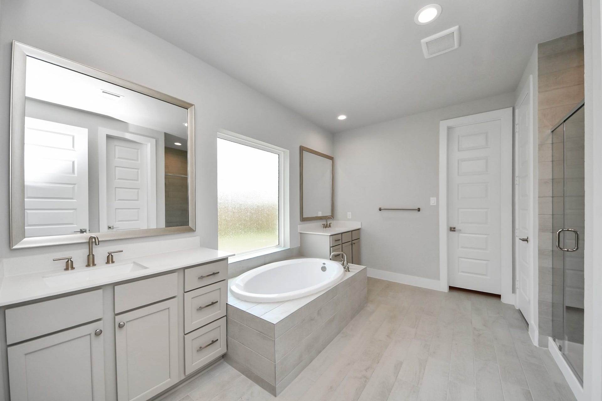 3205 Skerne Spring Drive, Spring, TX 77373 Escape to a spa-like oasis in this primary bathroom. Enjoy a walk-in shower with tile surround, a separate garden tub with custom detailing, and an elegant vanity featuring light countertops, modern hardware, and beautiful recessed lights. Experience luxury and relaxation in every detail. Sample photo of completed home with similar floor plan. Actual colors and selections may vary.