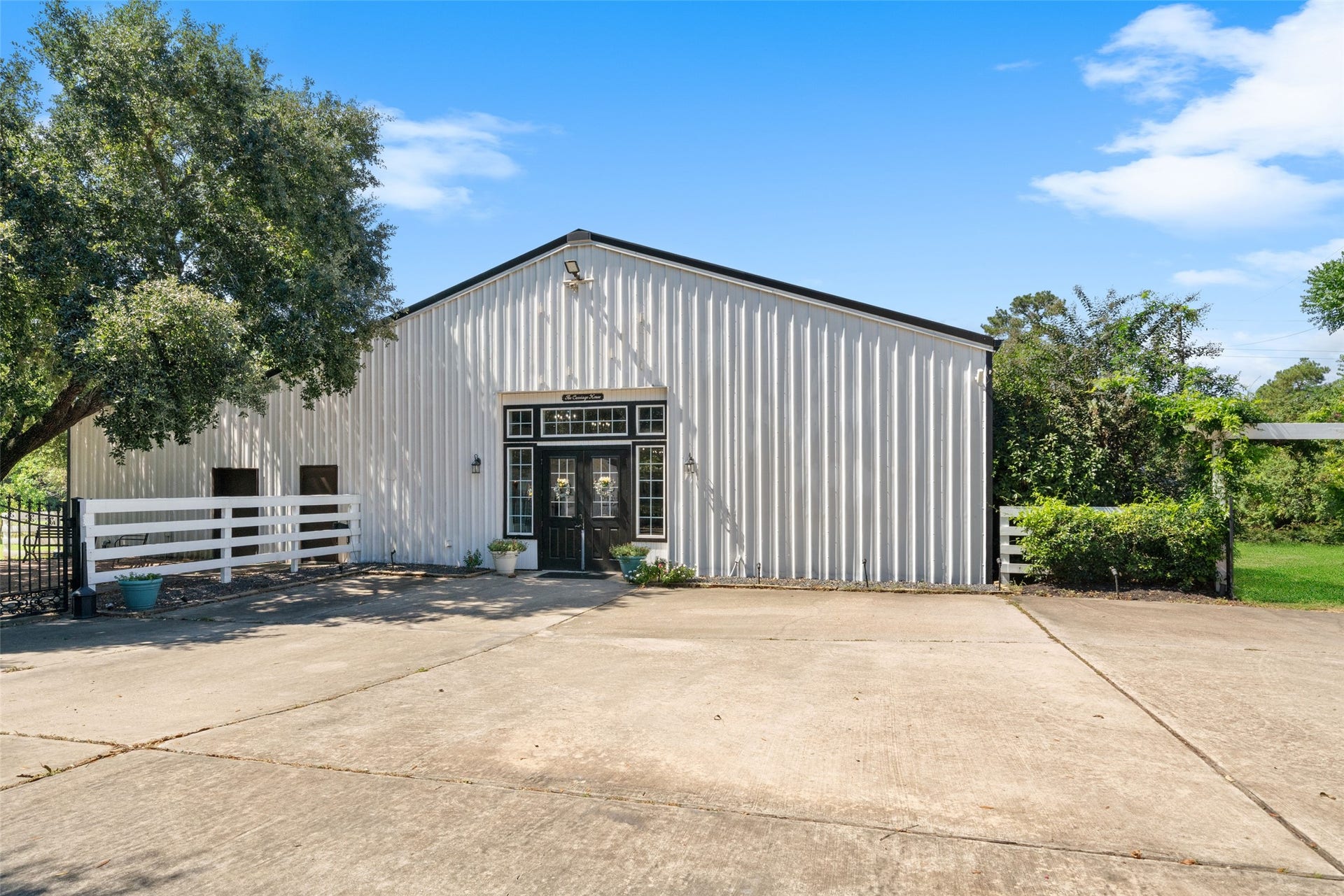 Reception hall exterior featuring metal siding, double entry doors, and a broad paved approach.
