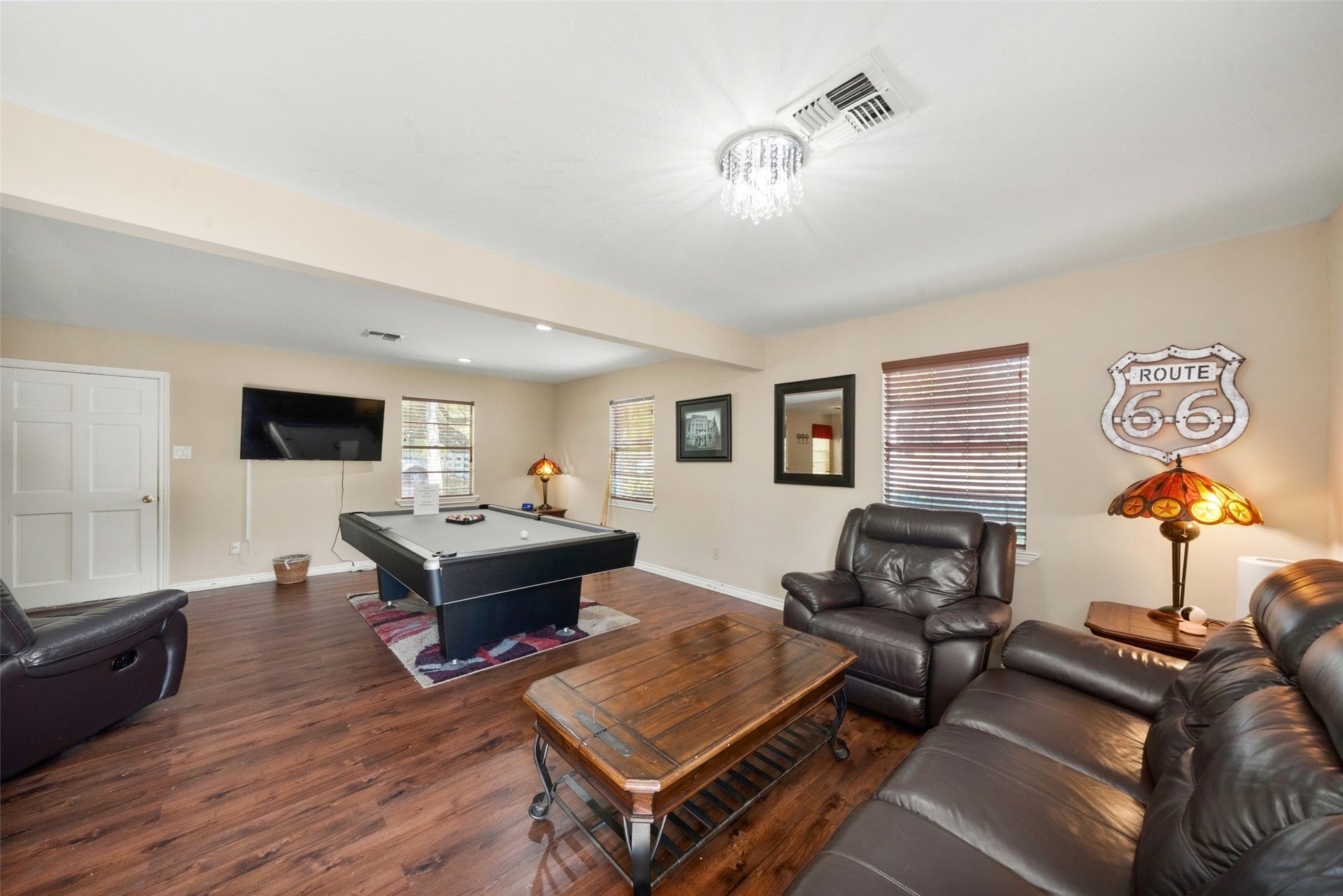 Guest house living area featuring wood flooring, a ceiling fan, and an open layout connecting to the kitchen and dining space.