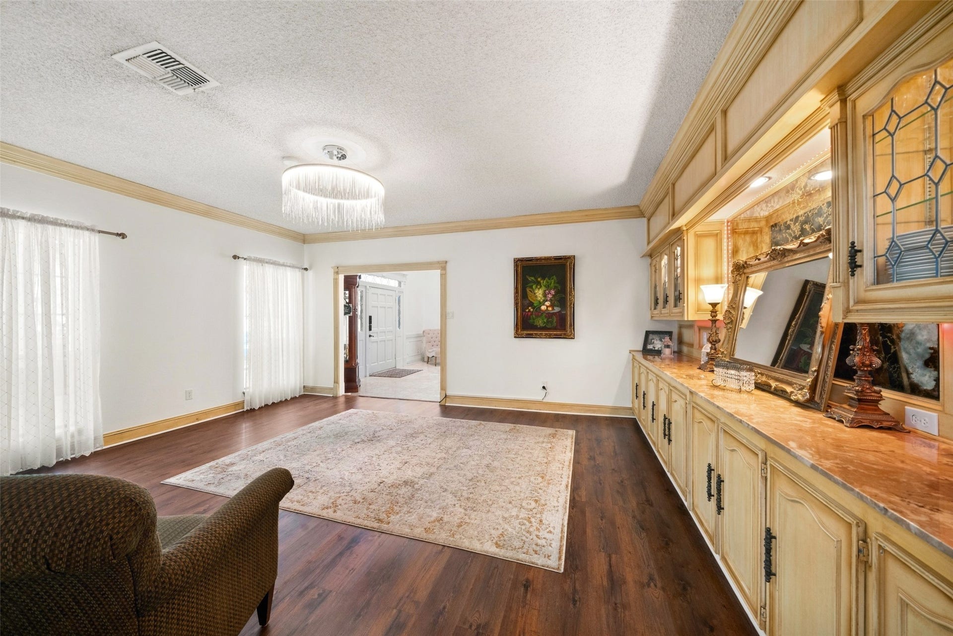 Alternate view of the sitting room showcasing built-in storage, wood flooring, and adjoining interior access.