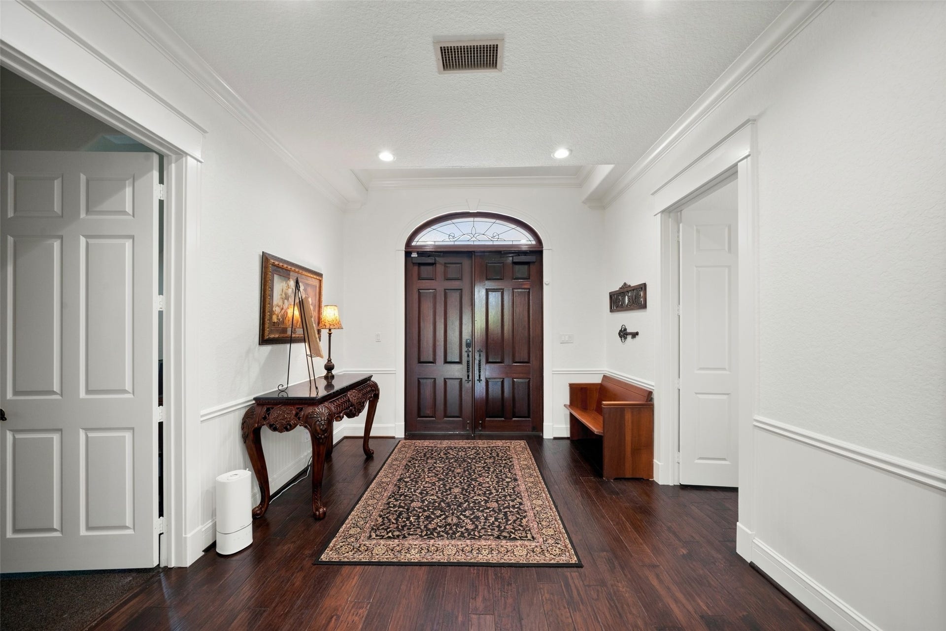 Inviting chapel entry features white trim, dark flooring, and double doors with decorative glass leading into the ceremony space.