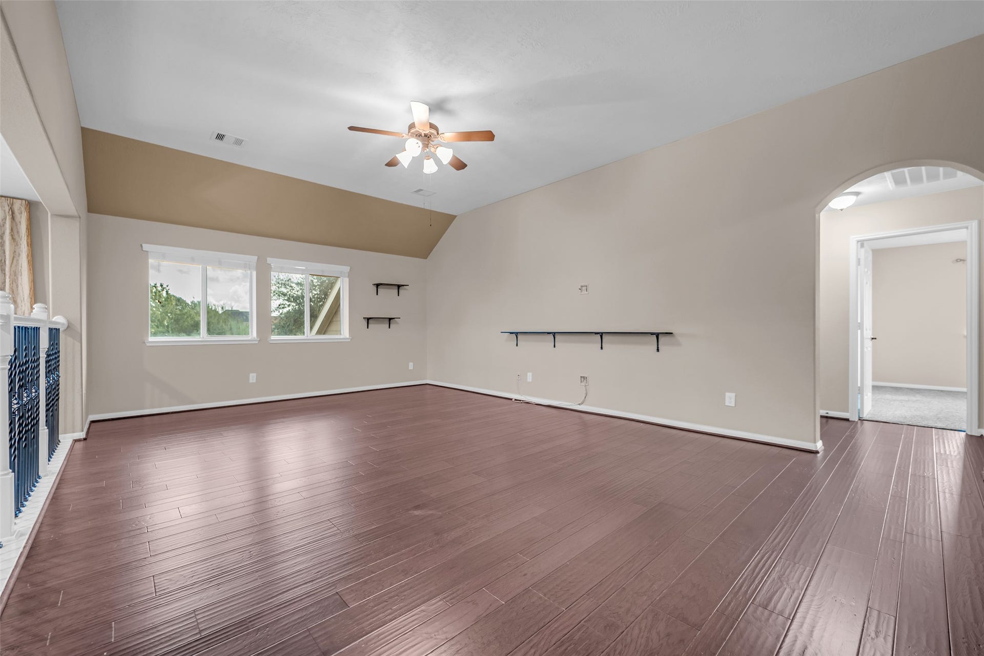 7907 Dunlap Field Lane, Richmond, TX 77407 Spacious multipurpose room boasting rich wood floors, a functional ceiling fan, and large sunlit windows throughout.