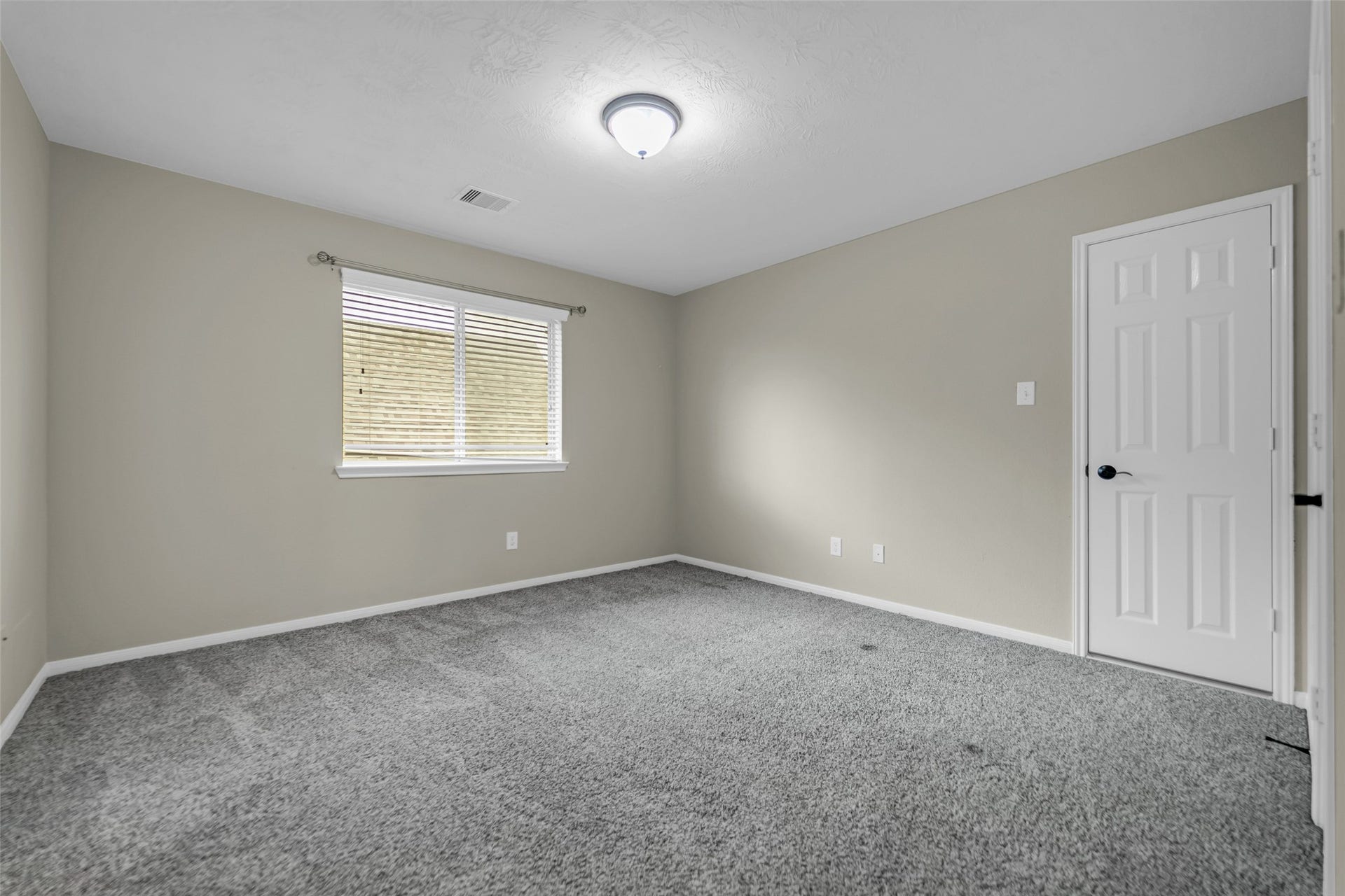 7907 Dunlap Field Lane, Richmond, TX 77407 Inviting bedroom suite featuring plush carpet flooring, clean neutral walls, and a large sunlit window creating a bright, comfortable retreat.