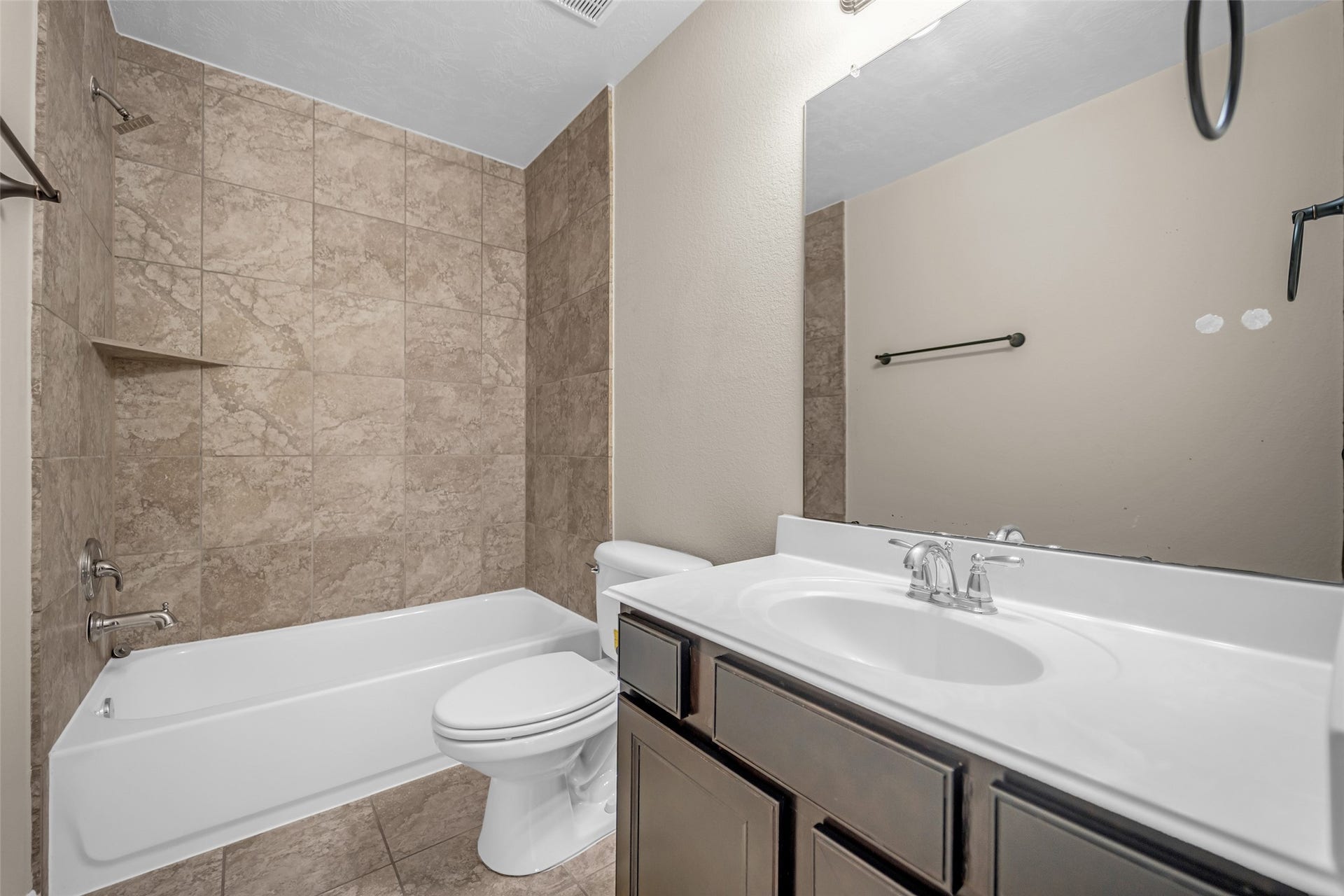 7907 Dunlap Field Lane, Richmond, TX 77407 Refined full bath featuring a sleek vanity with modern fixtures, timeless tile work, and a classic shower-tub combination.