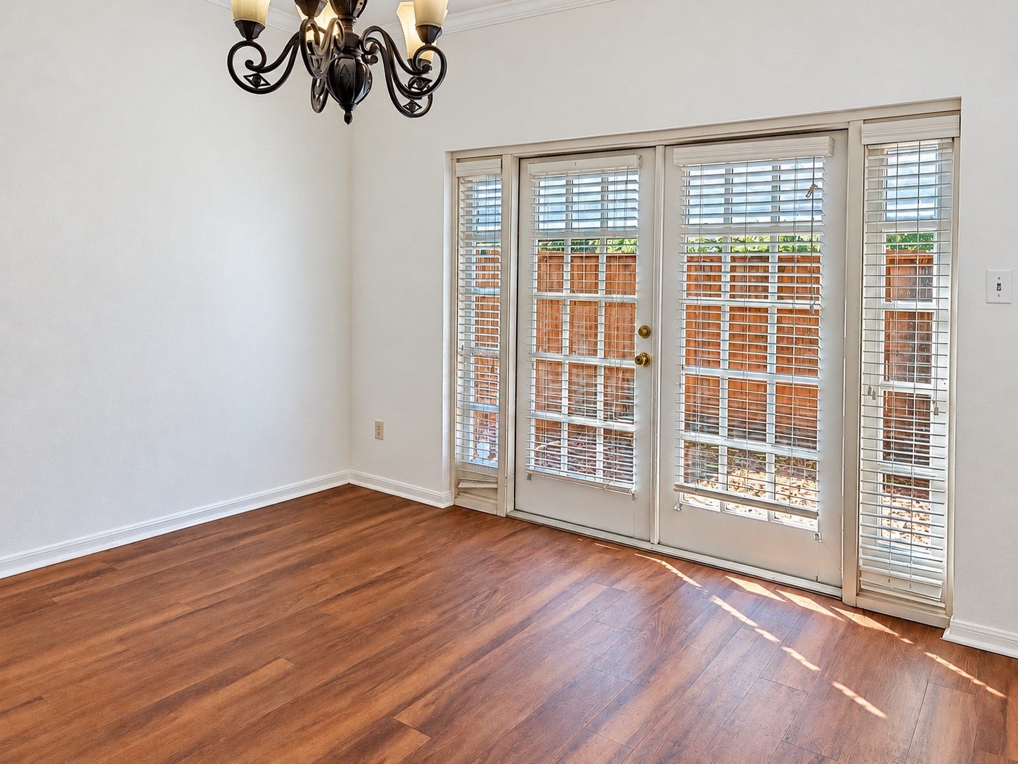 11711 Memorial Drive, #313, Houston, TX 77024 Natural lit dining area with wood-look flooring, a decorative chandelier,French doors opening to the peaceful private fenced patio.