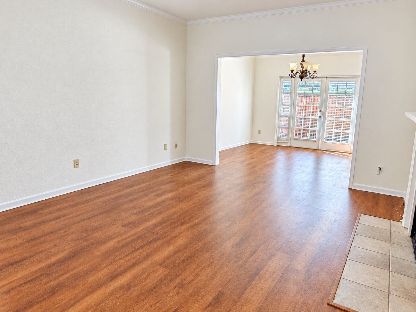 11711 Memorial Drive, #313, Houston, TX 77024 Inviting living area with wooded look flooring, crown molding, and adjoining dining space filled with natural lighting