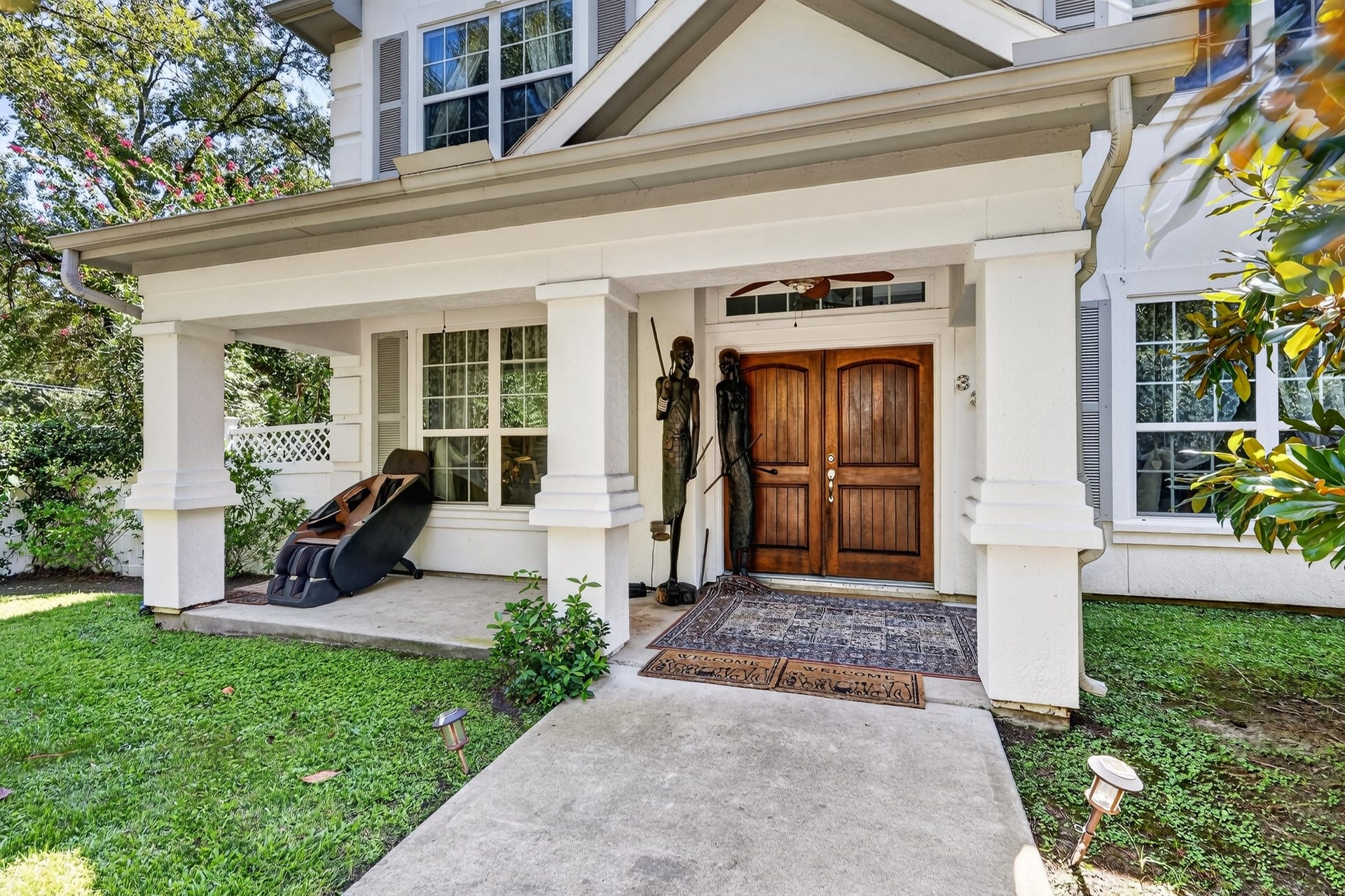 Inviting entry with custom front door and covered veranda.