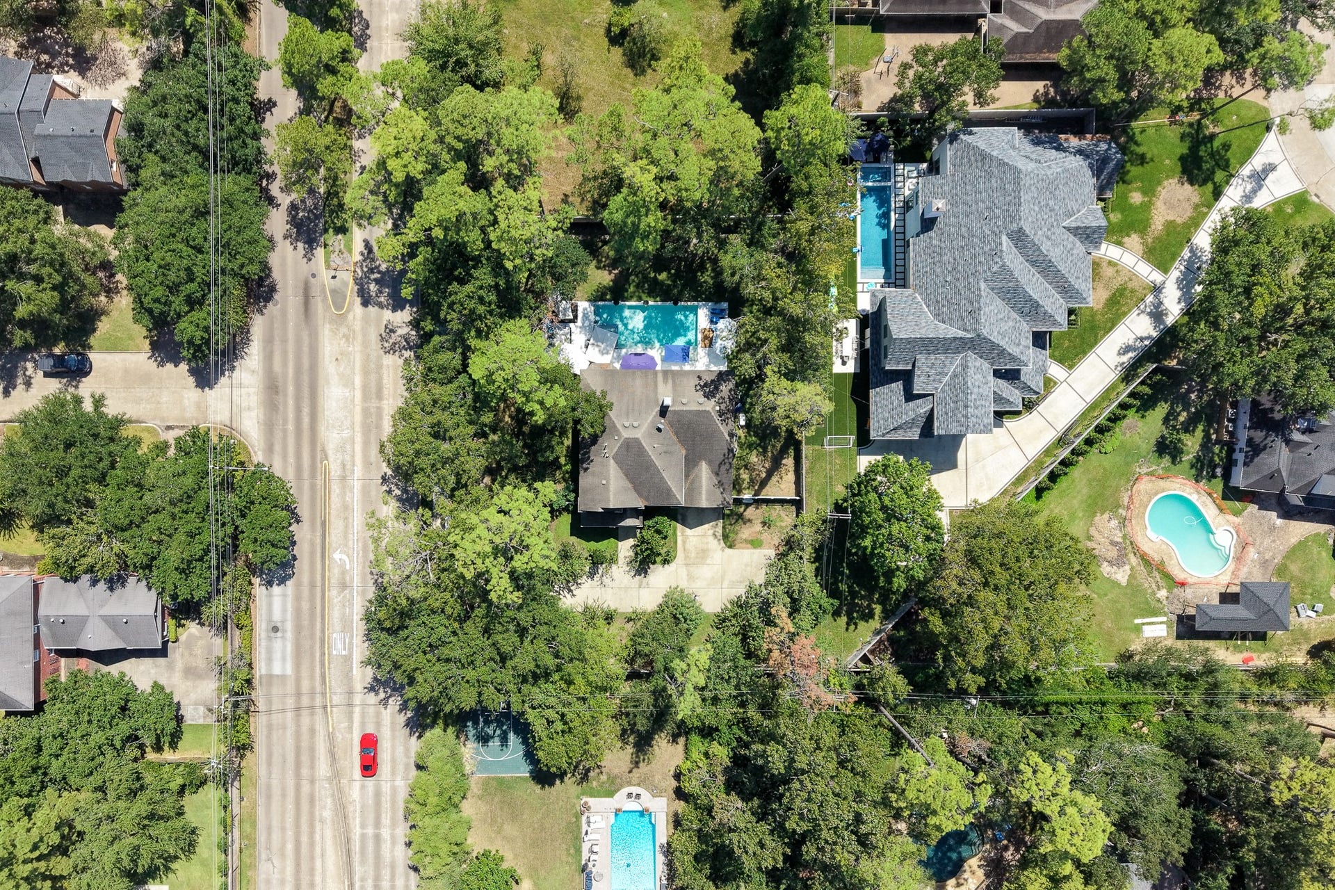Expansive property footprint surrounded by lush greenery and neighboring estates.