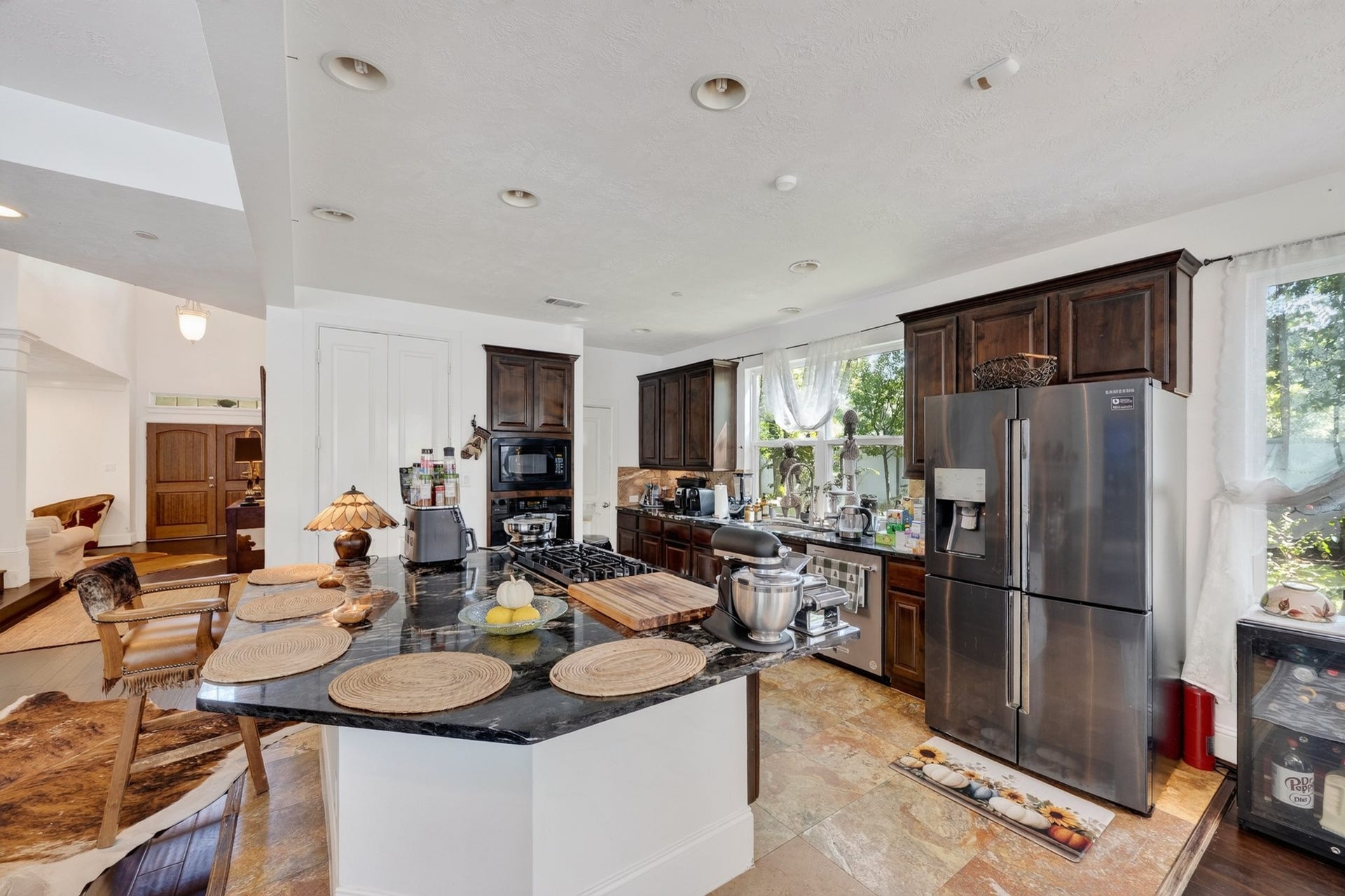 Designed for both everyday living and entertaining, this gourmet kitchen offers extensive red marble countertop, premium finishes, and seamless flow to surrounding living areas.