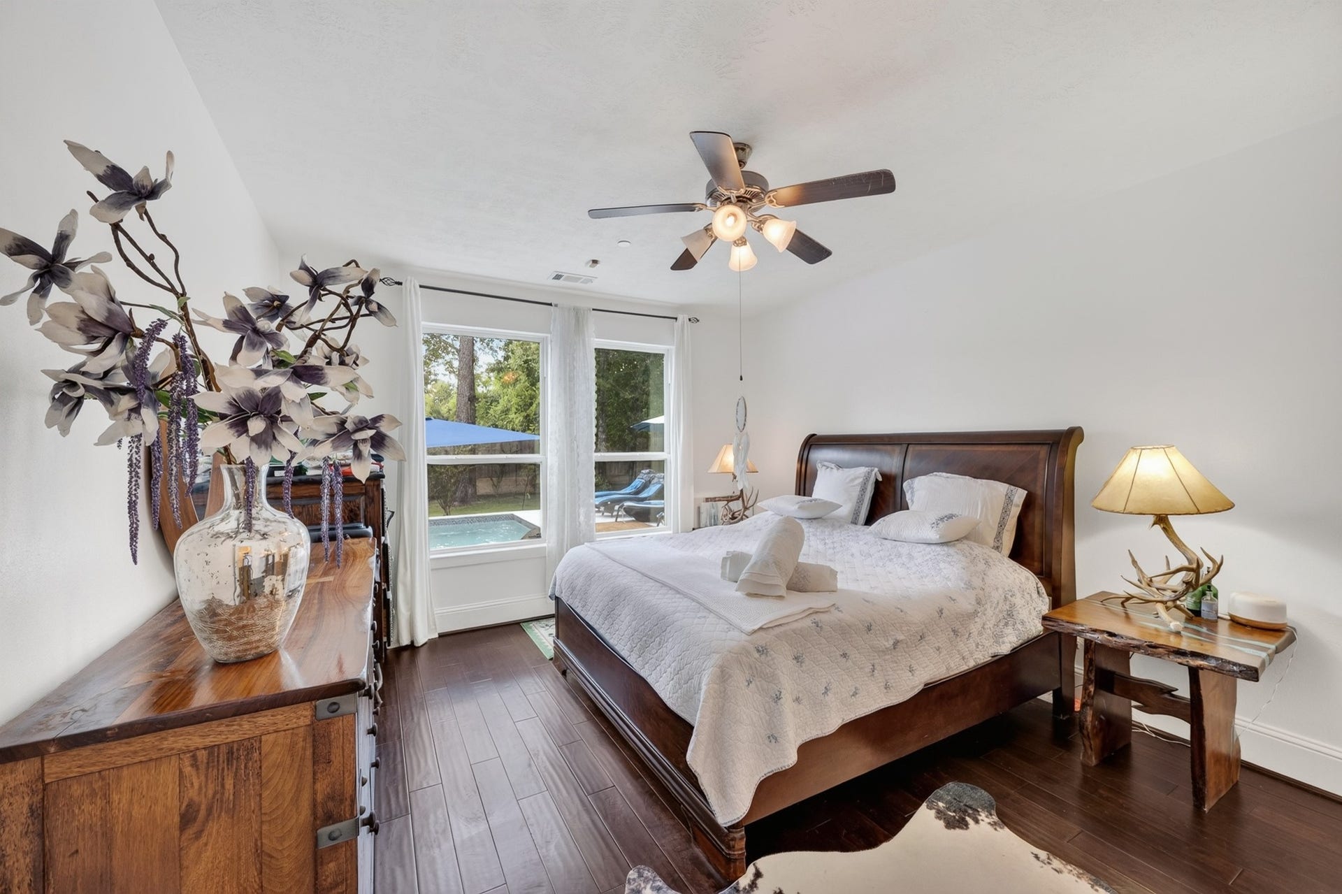 Downstairs primary bedroom offers comfort, style, and privacy & pool view.
