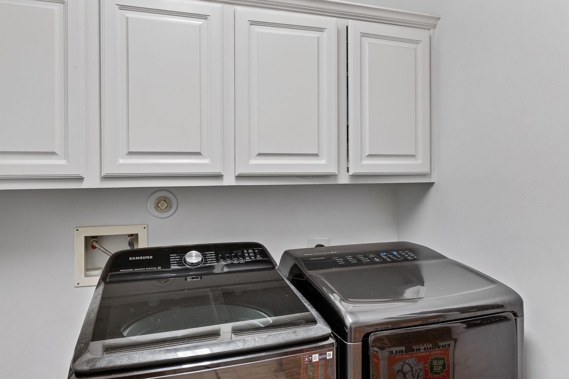 Functional laundry room with extensive cabinetry and storage.