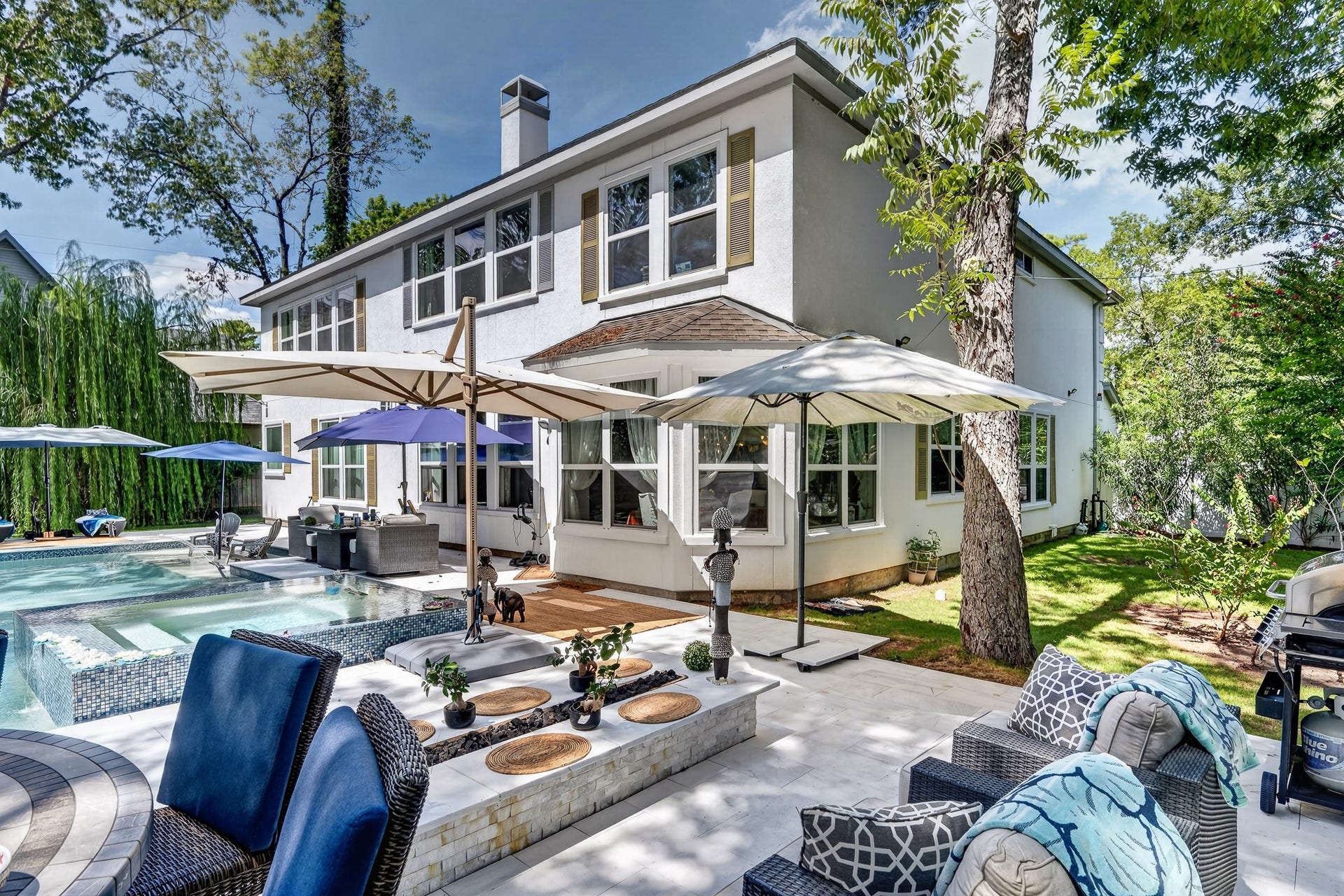 Exceptional outdoor oasis featuring multiple gathering areas and a sparkling pool.
