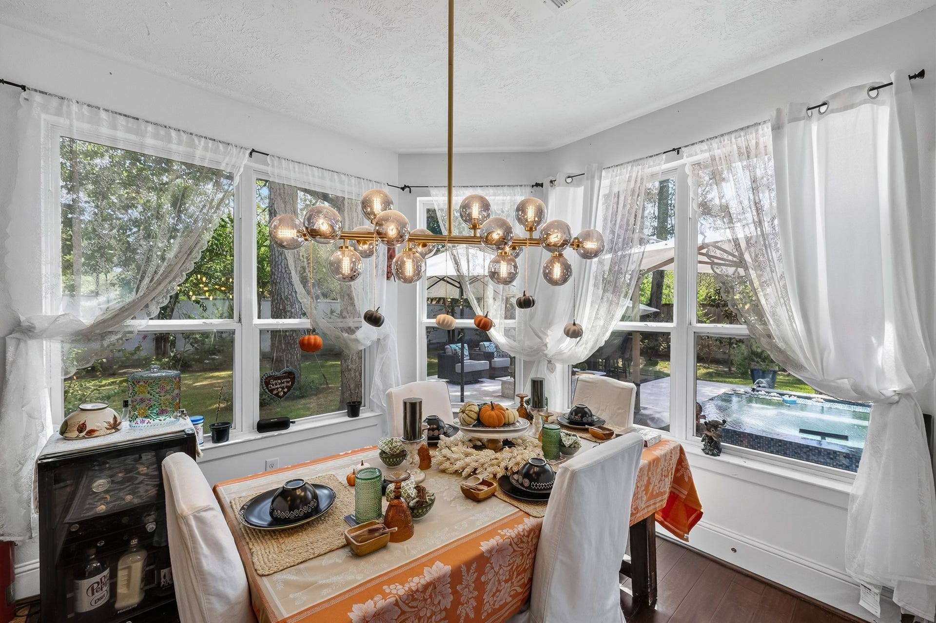 Charming breakfast area surrounded by picturesque backyard and pool view.