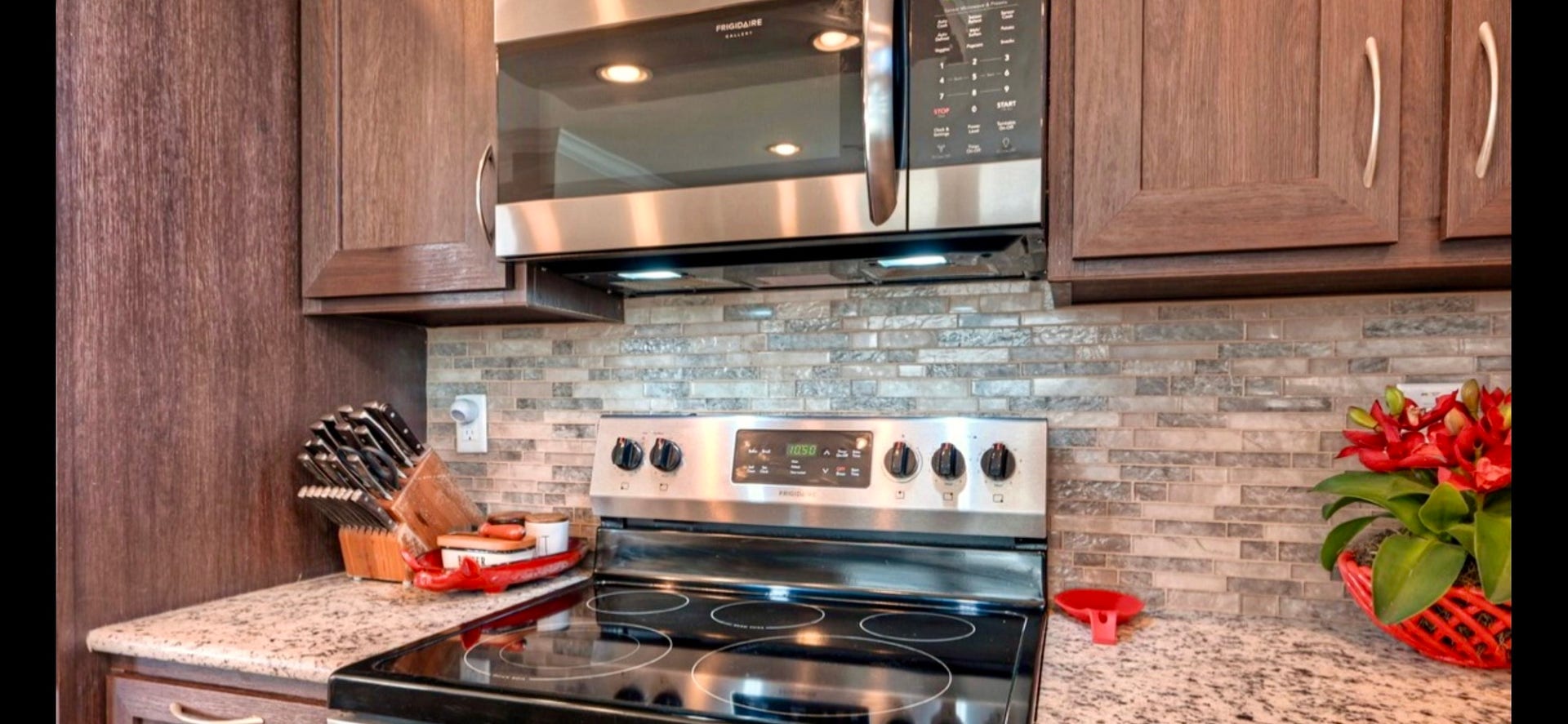 11720 Thousand Trails Road, #73, Willis, TX 77318 Electric range, tile backsplash & surrounding cabinetry create a practical cooking space in this inviting kitchen.