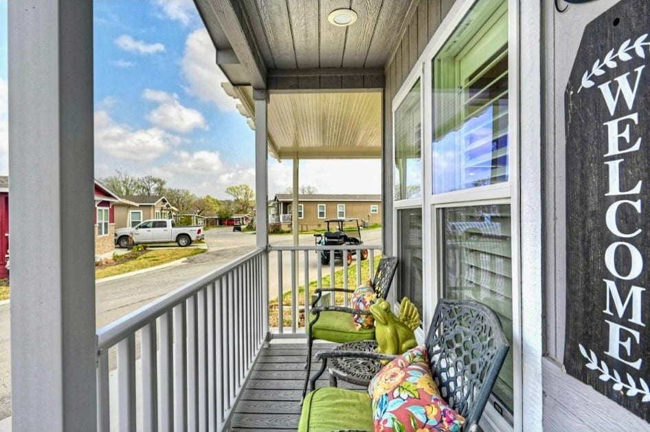 11720 Thousand Trails Road, #73, Willis, TX 77318 Relax on the covered front porch with room for seatinga welcoming spot to enjoy morning coffee or unwind outdoors.