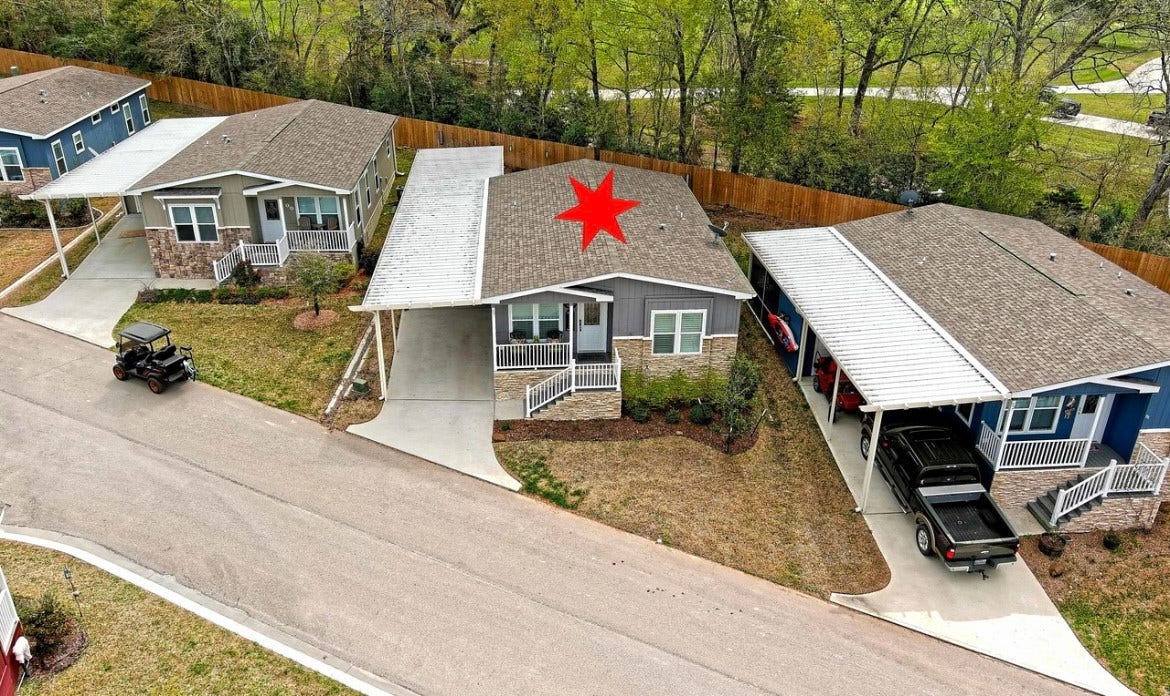 11720 Thousand Trails Road, #73, Willis, TX 77318 Aerial perspective showcases the home & covered parking within Thousand Trails, a community offering lake access, a boat ramp & recreational amenities. Home only; land leased.