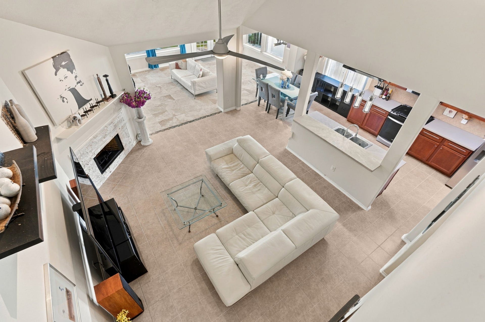 Spacious open-concept living area and a stylish fireplace. The room flows seamlessly into a dining space and a well-appointed kitchen, creating an inviting atmosphere for entertaining.