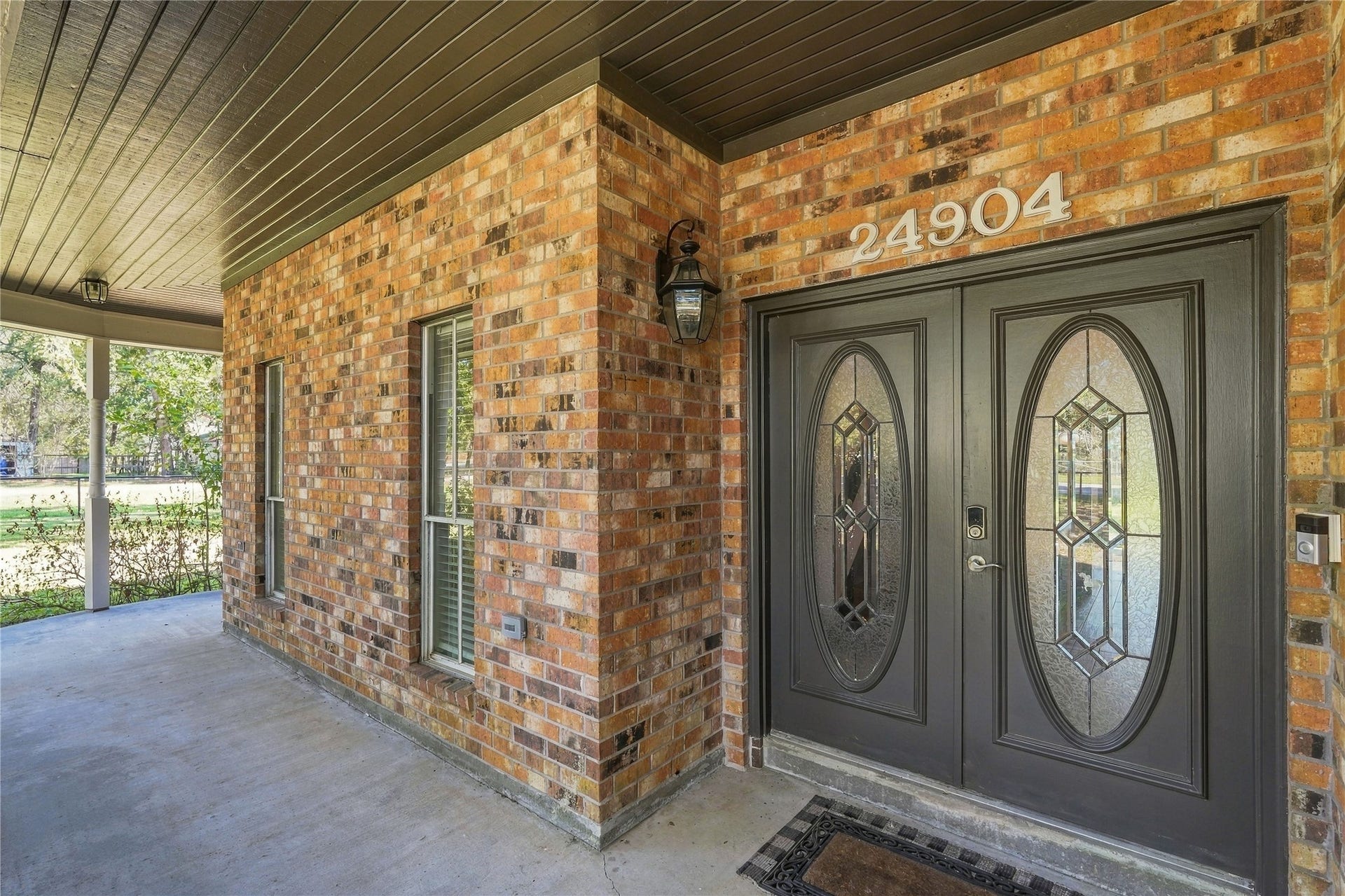 24904 Robin Hood Lane, Hockley, TX 77447 Welcoming covered front porch with decorative glass double entry doors and classic brick exterior.