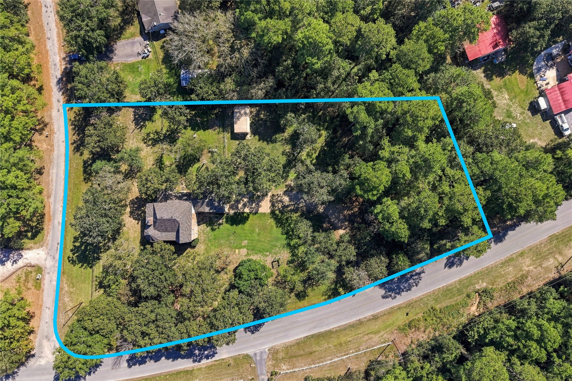 24904 Robin Hood Lane, Hockley, TX 77447 Aerial view highlighting the property's wooded setting, home, outdoor improvements, and approximate property boundaries. *Property lines shown are approximate and for illustrative purposes only. Not a survey. Buyer to independently verify property boundaries.