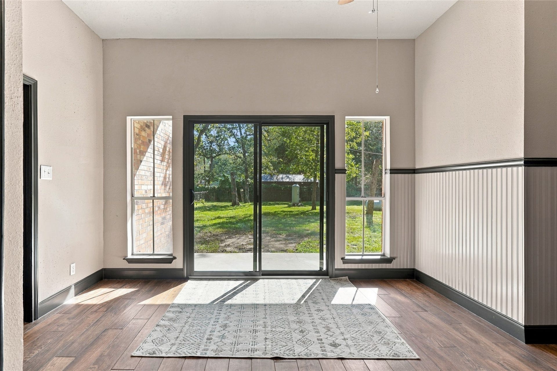 24904 Robin Hood Lane, Hockley, TX 77447 Light-filled breakfast room with new sliding glass doors leading to the backyard patio, large windows, and decorative wainscoting.