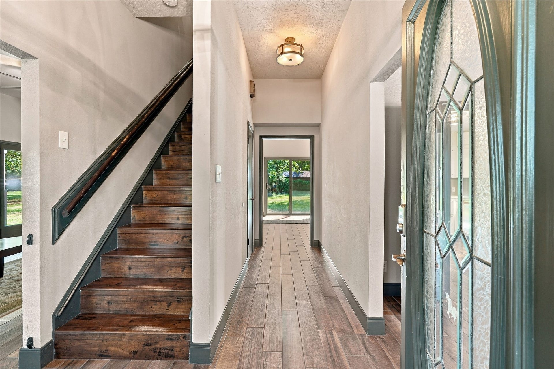 24904 Robin Hood Lane, Hockley, TX 77447 Inviting entryway featuring wood-look flooring, staircase with wood treads, and views toward the rear of the home.