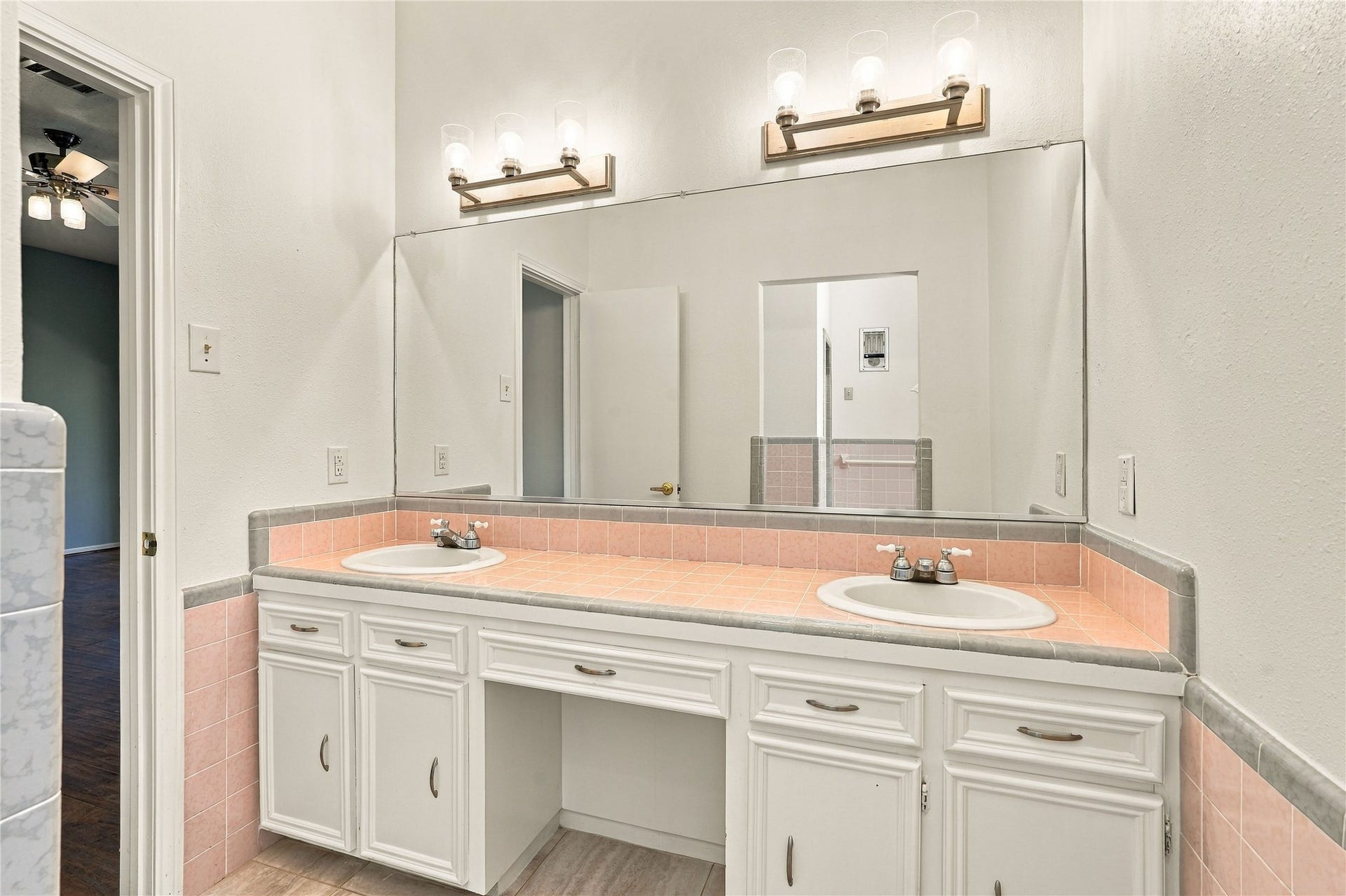 24904 Robin Hood Lane, Hockley, TX 77447 Primary bathroom featuring double sinks, an extended tile countertop, large vanity mirror, and ample cabinet storage.
