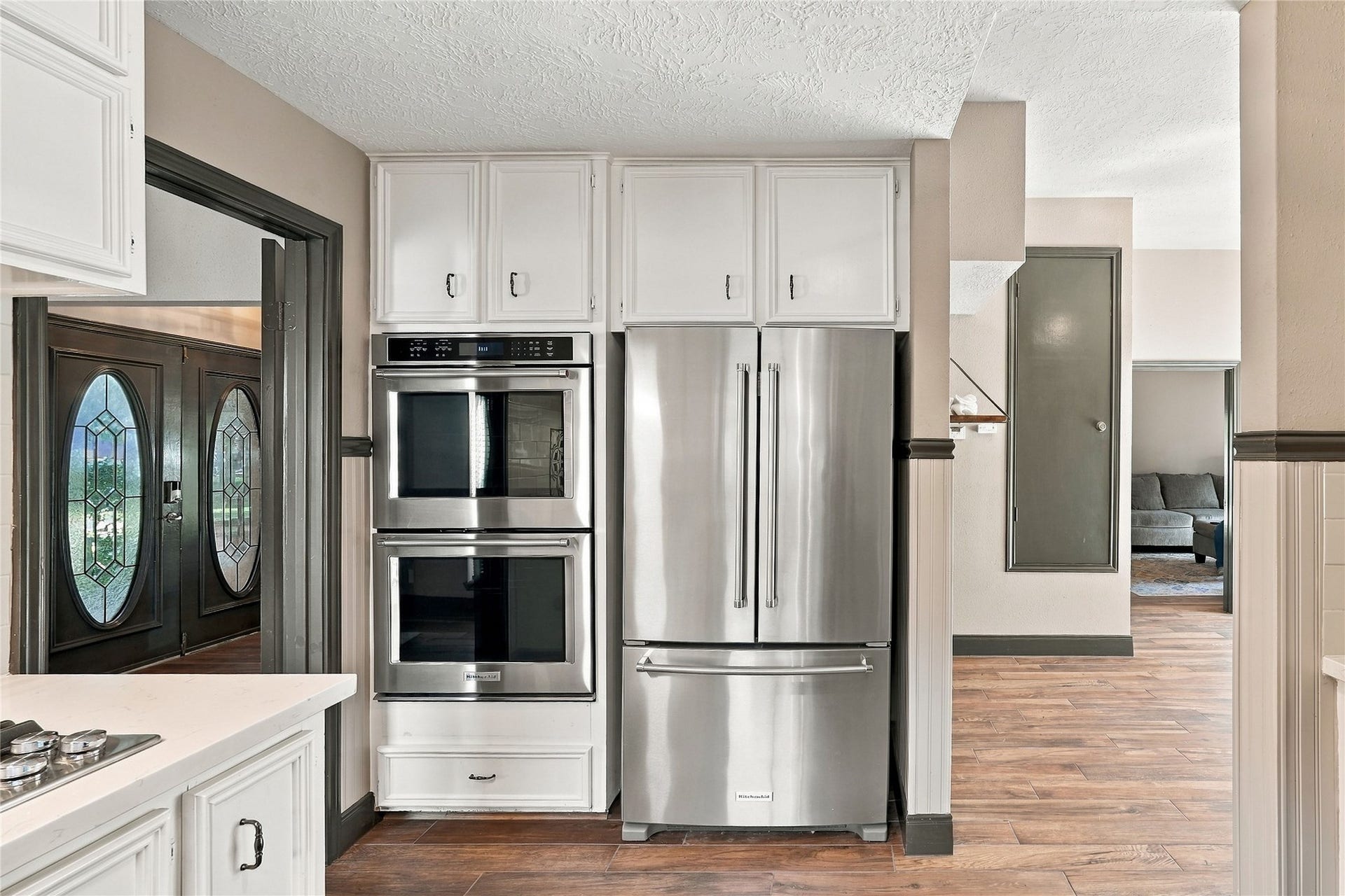 24904 Robin Hood Lane, Hockley, TX 77447 Stainless steel double ovens and French-door refrigerator surrounded by white cabinetry, with convenient access to the adjoining living areas.