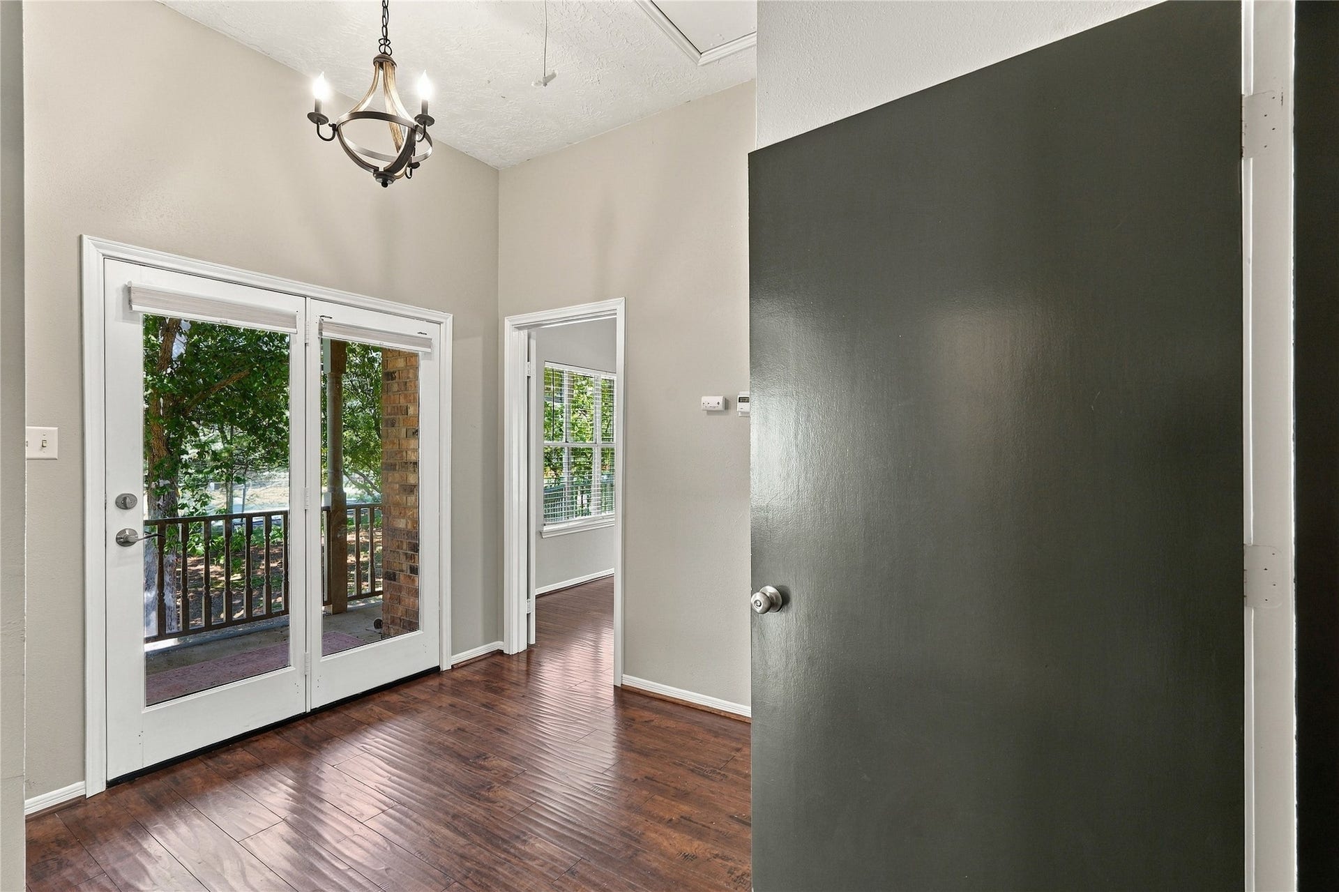 24904 Robin Hood Lane, Hockley, TX 77447 Upstairs landing with wood flooring, high ceilings, and French doors leading to the covered second-floor balcony.