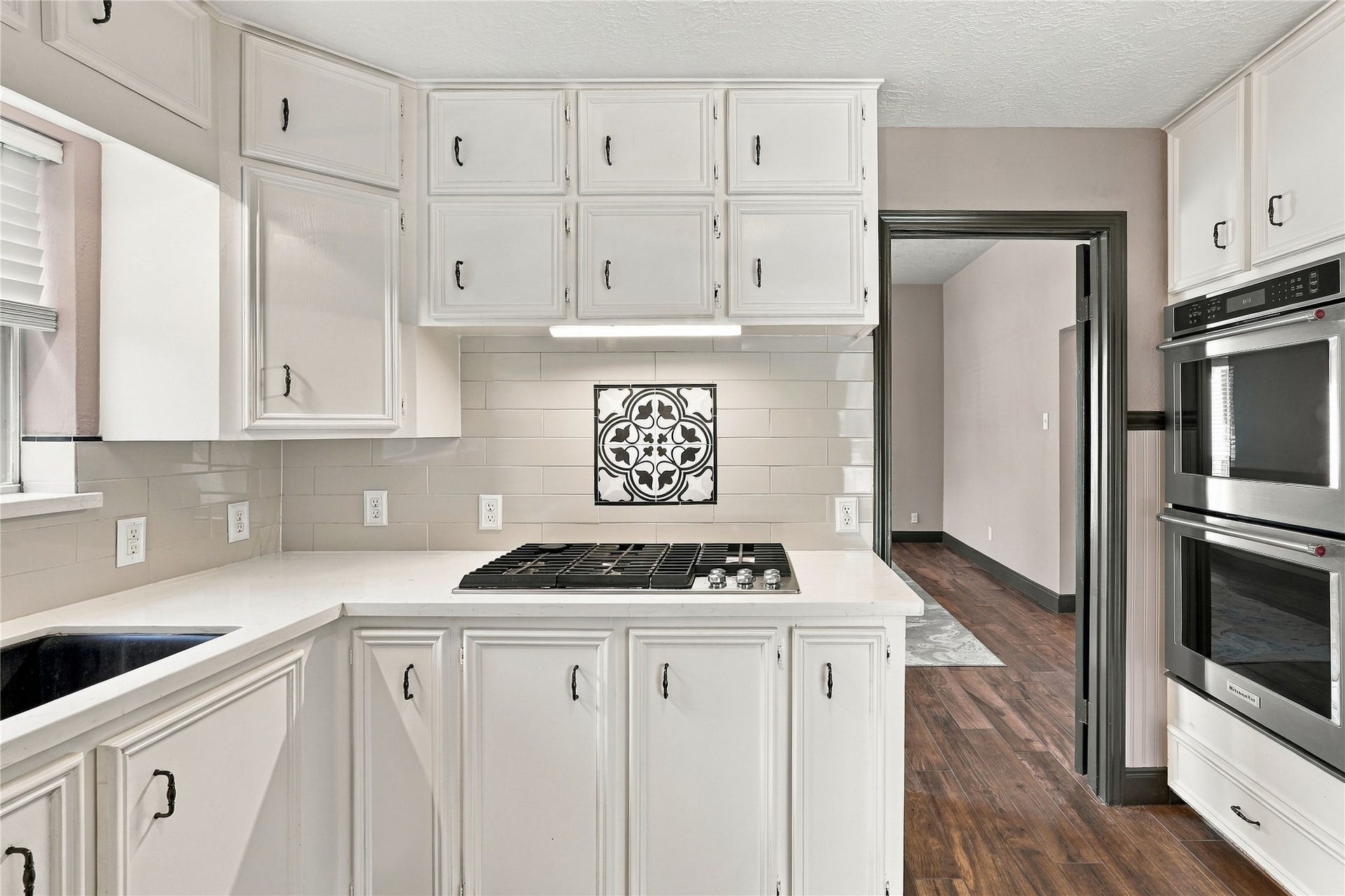 24904 Robin Hood Lane, Hockley, TX 77447 Kitchen featuring a built-in gas cooktop, decorative tile backsplash accent, white cabinetry, and double wall ovens.