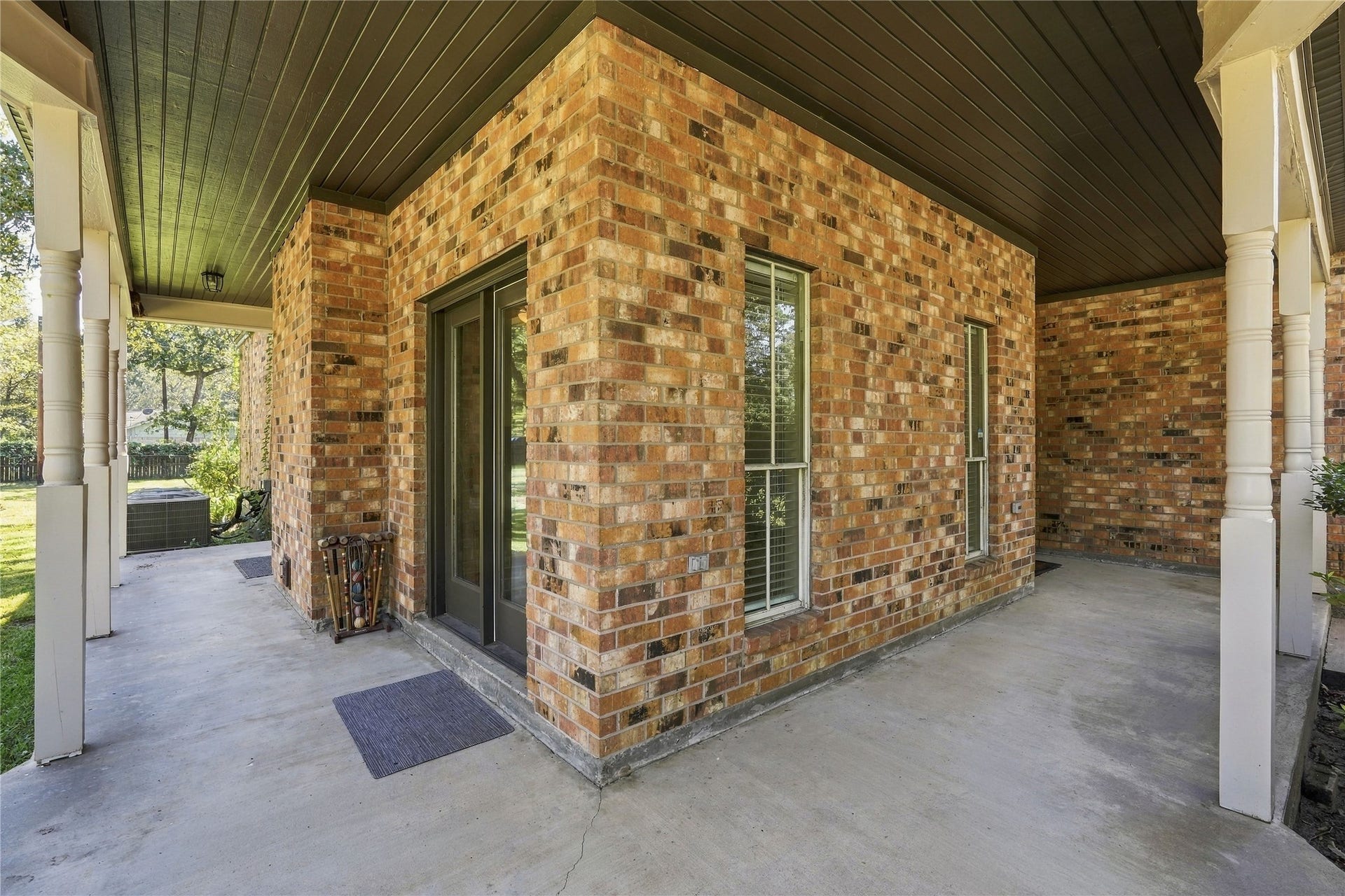 24904 Robin Hood Lane, Hockley, TX 77447 Covered ground-level patio with concrete flooring, brick exterior, and access to the surrounding yard.