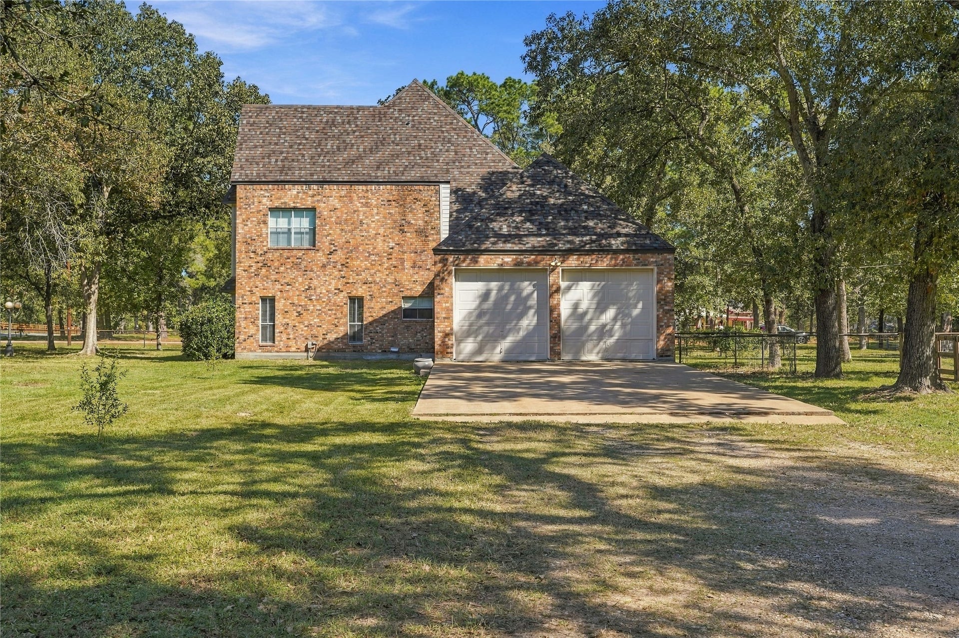 24904 Robin Hood Lane, Hockley, TX 77447 Attached two-car oversized garage with concrete parking area and convenient access from the gravel driveway.