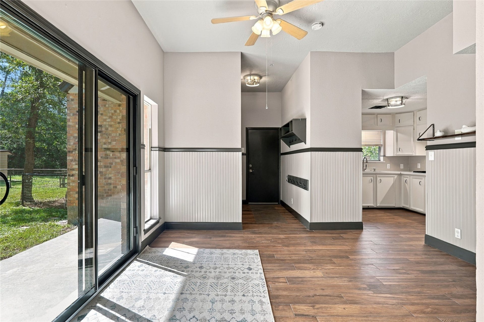 24904 Robin Hood Lane, Hockley, TX 77447 Spacious breakfast area featuring wood-look flooring, decorative wainscoting, and sliding glass doors opening to the backyard patio.