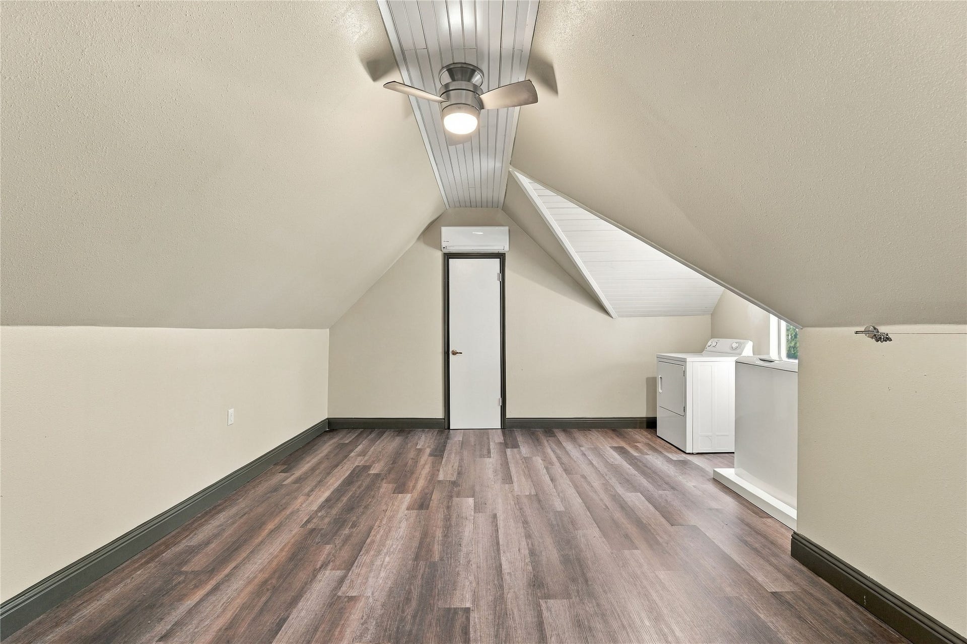 24904 Robin Hood Lane, Hockley, TX 77447 Spacious second-floor laundry and bonus room above the garage, featuring wood-look flooring, vaulted ceilings, and ceiling fan.